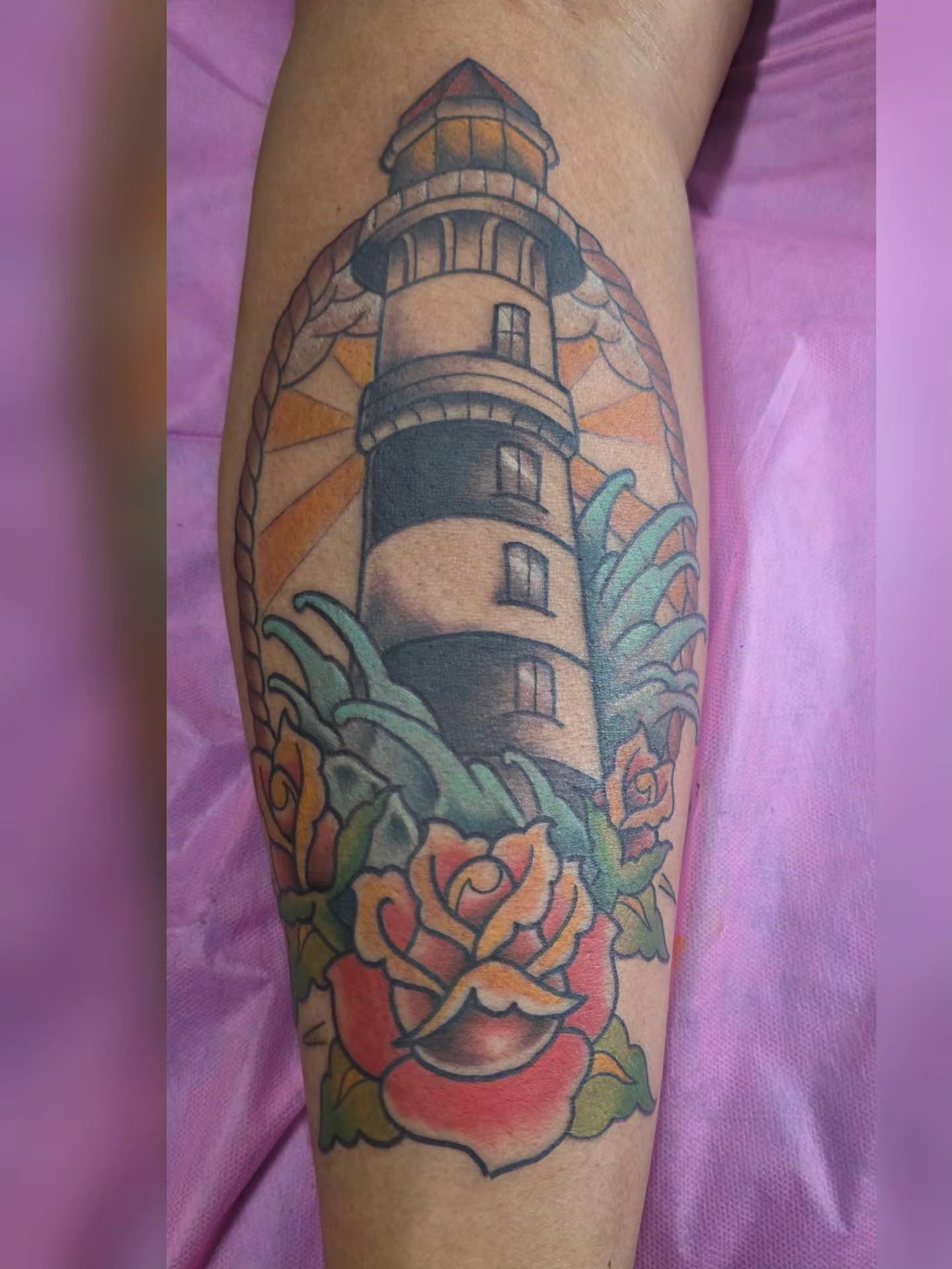 Lighthouse and roses American traditional tattoo on the forearm by Moe