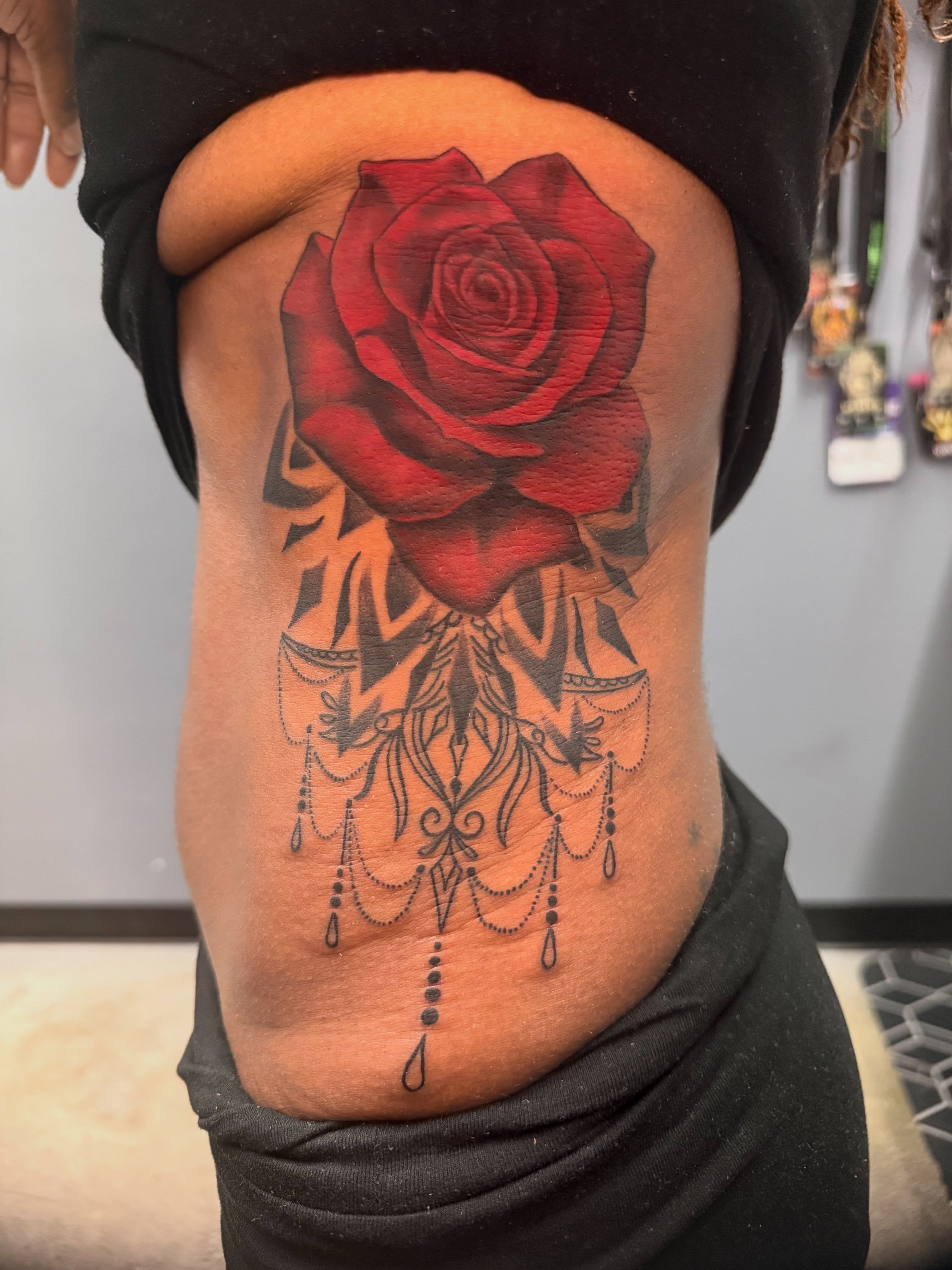 Red rose realism tattoo on the ribs by Butta