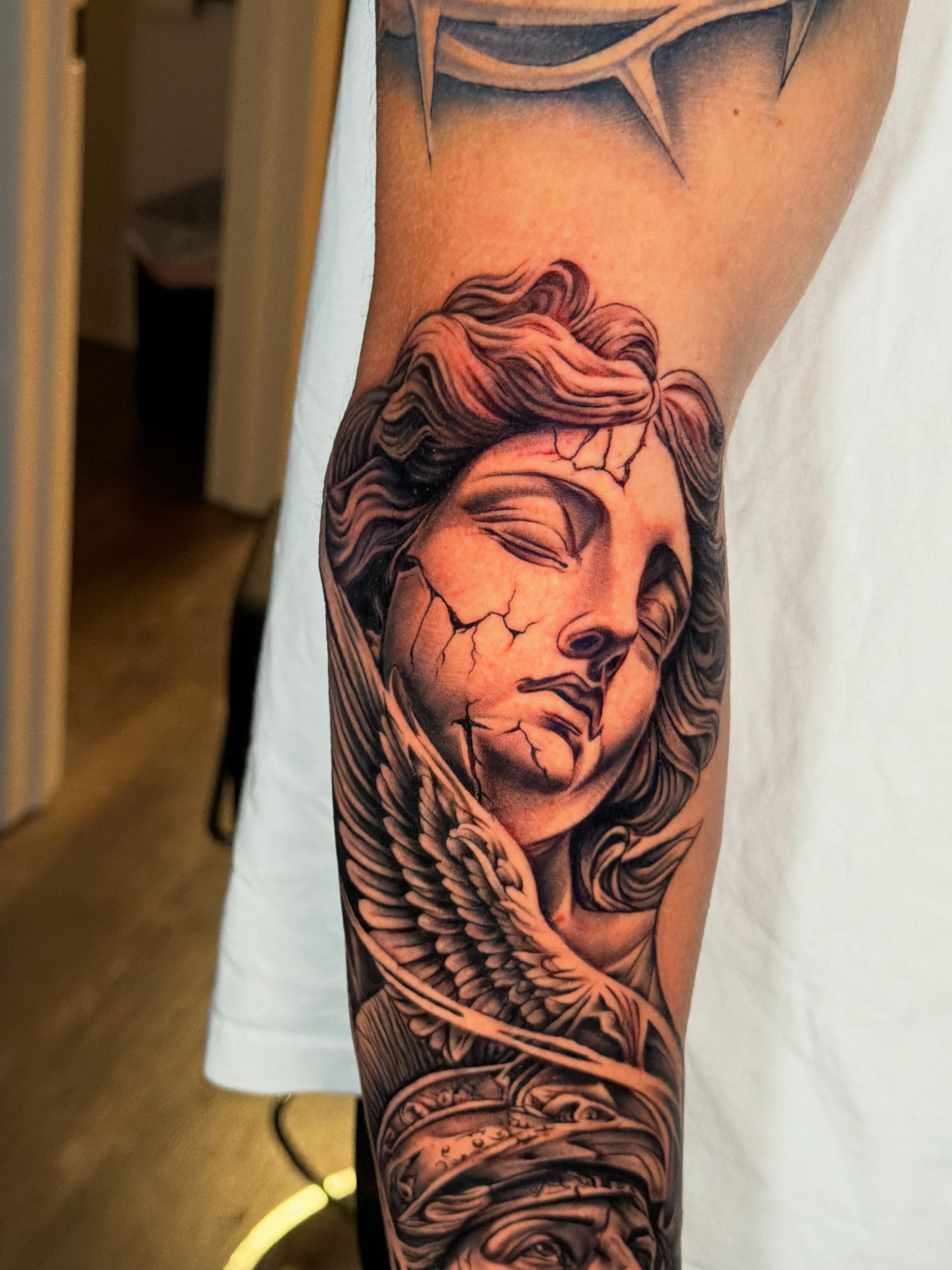 Angelic face realism tattoo on the forearm by Ray Paponetti - Tattoo Artist Delray Beach
