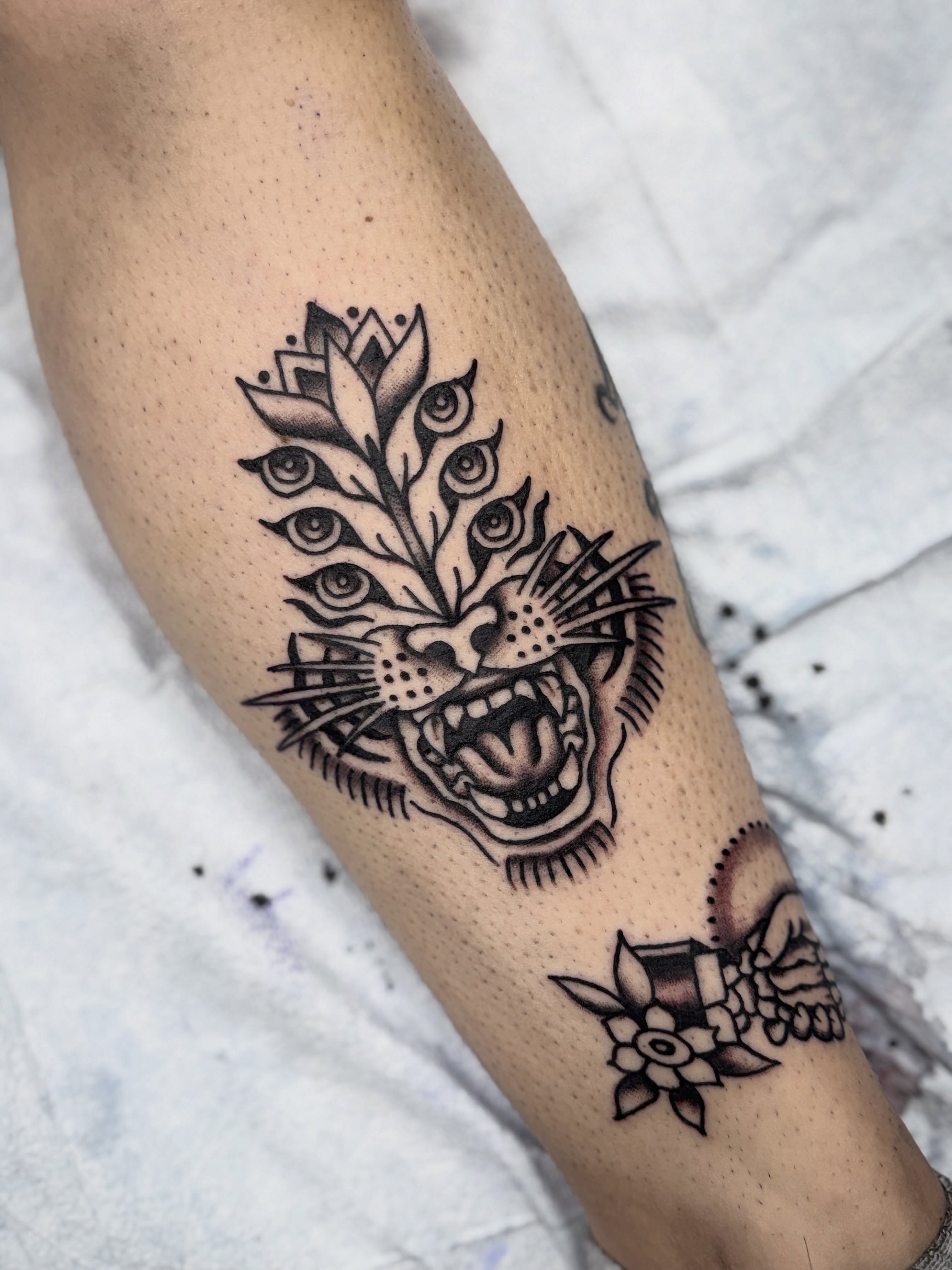 Tiger head with eyes black and grey tattoo on the forearm by Shannon Pagliarini