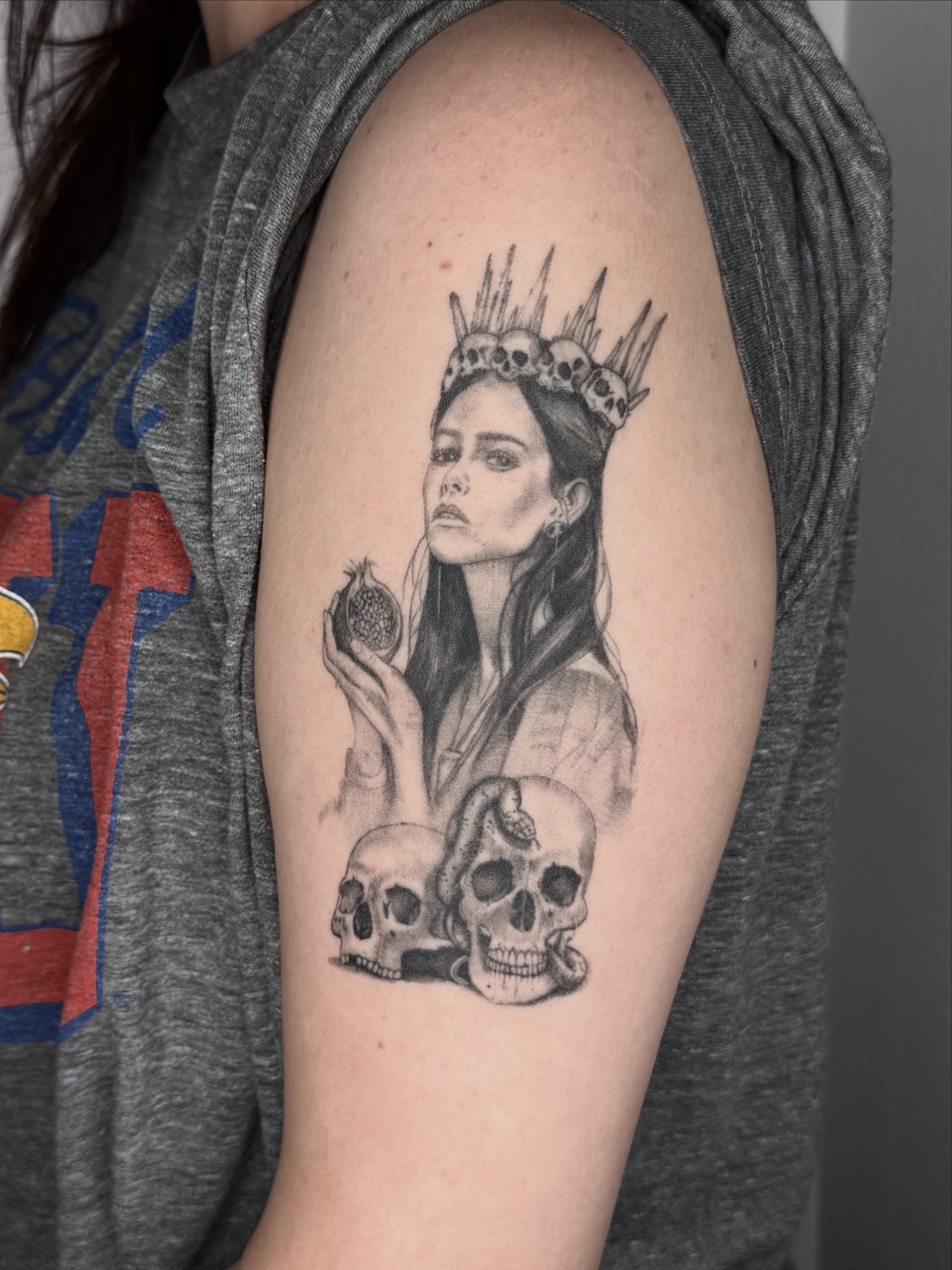 Woman with crown realism tattoo on the upper arm by Ashley Limon