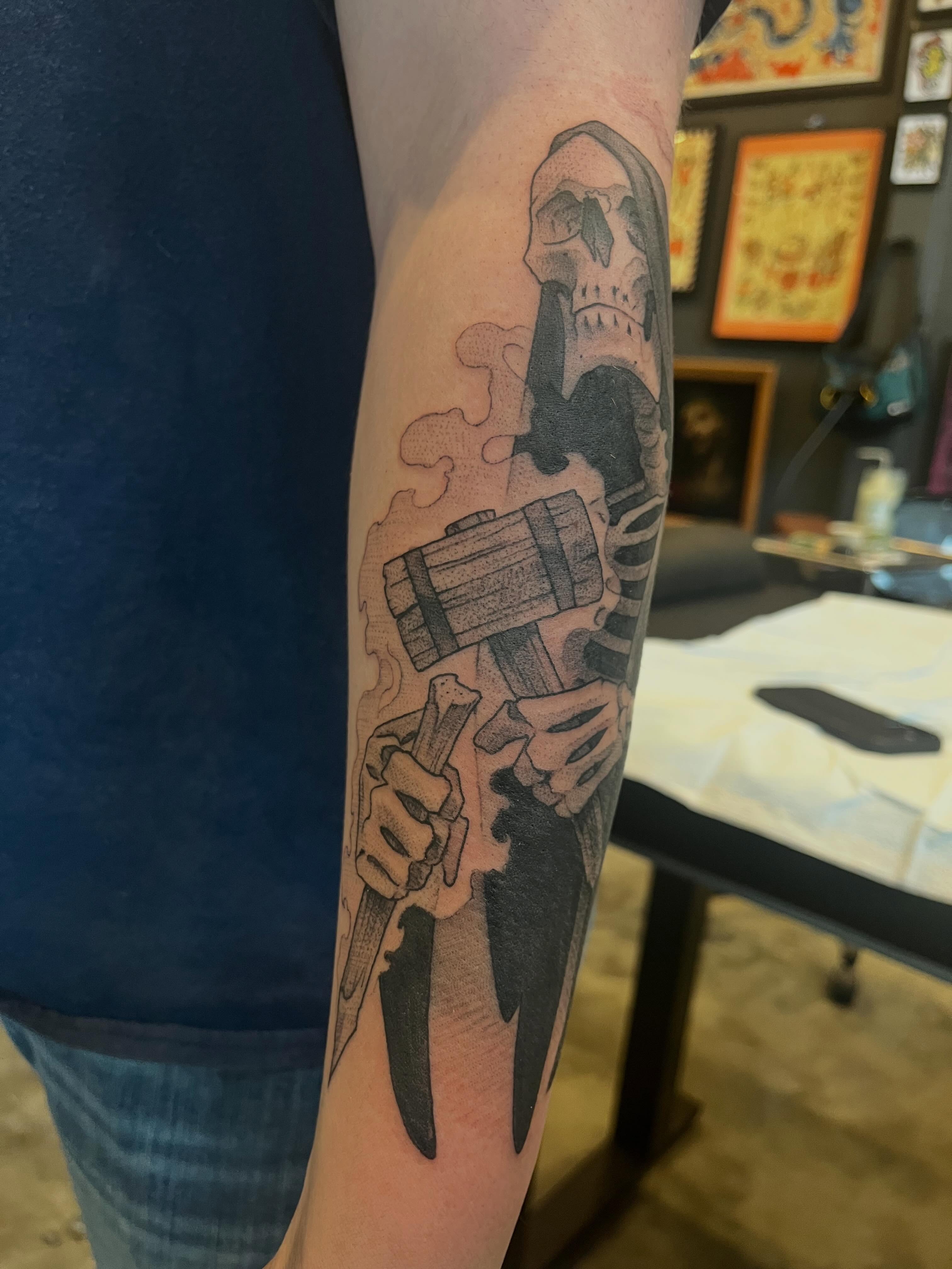 Skull and hammer black and grey tattoo on the forearm by Ian White