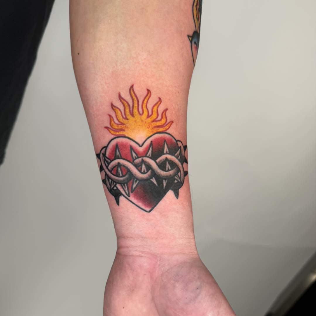 Heart with infinity symbol neo-traditional tattoo on the forearm by Tattoos by Aeron Herald Maurbjorn, Sioux