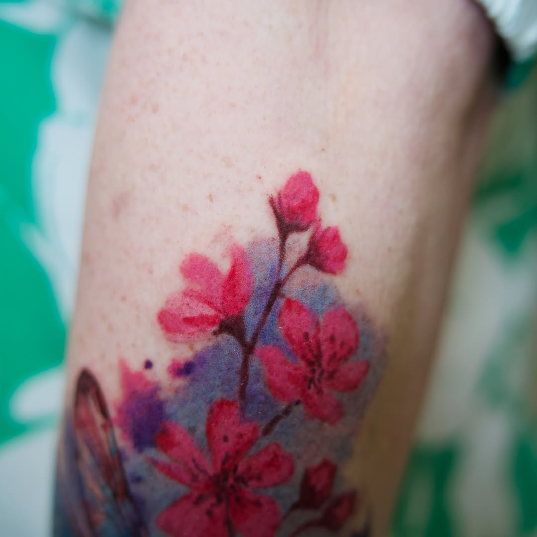 Cherry blossoms watercolor tattoo on the forearm by Raven Wood