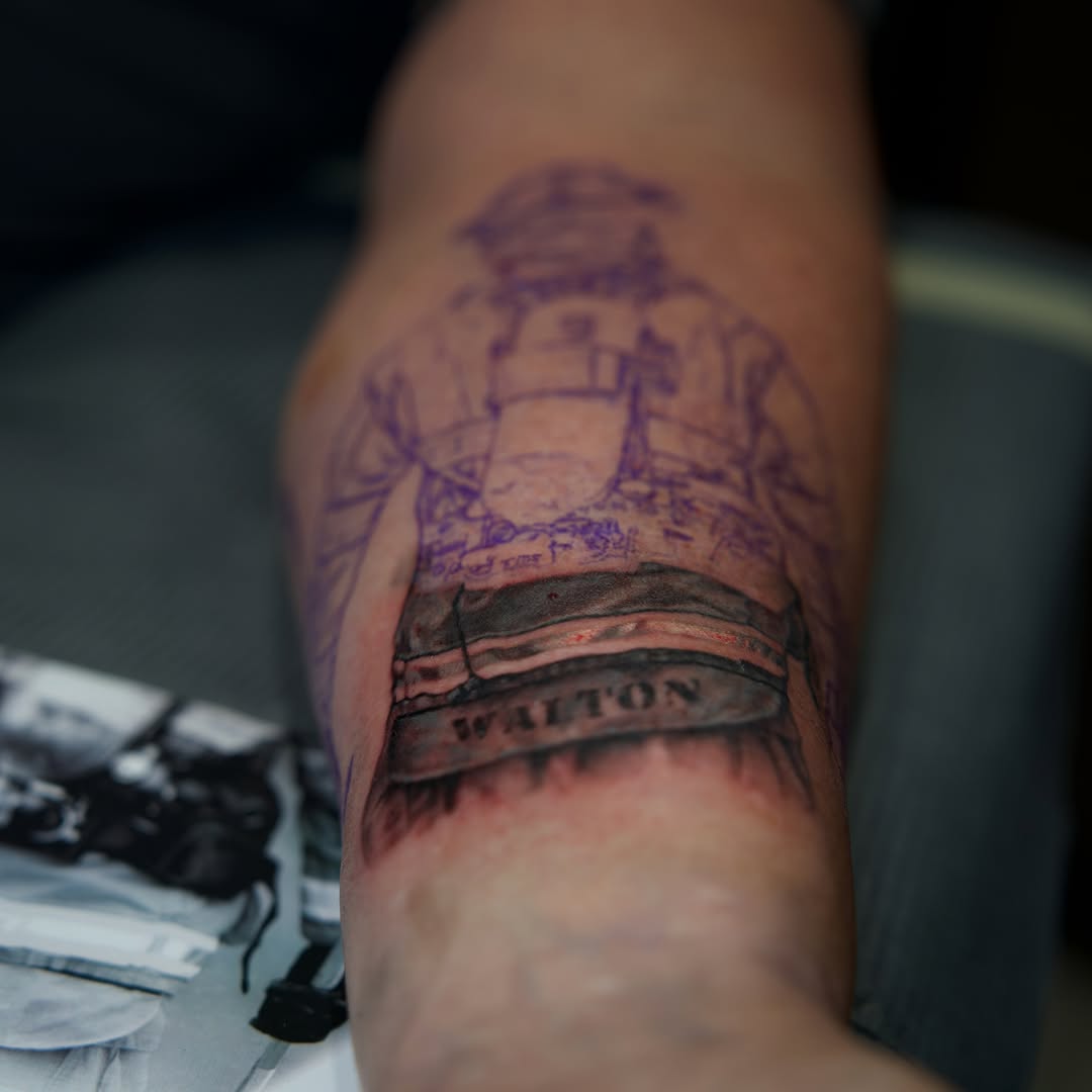 Ship and banner black and grey tattoo on the forearm by Raven Wood