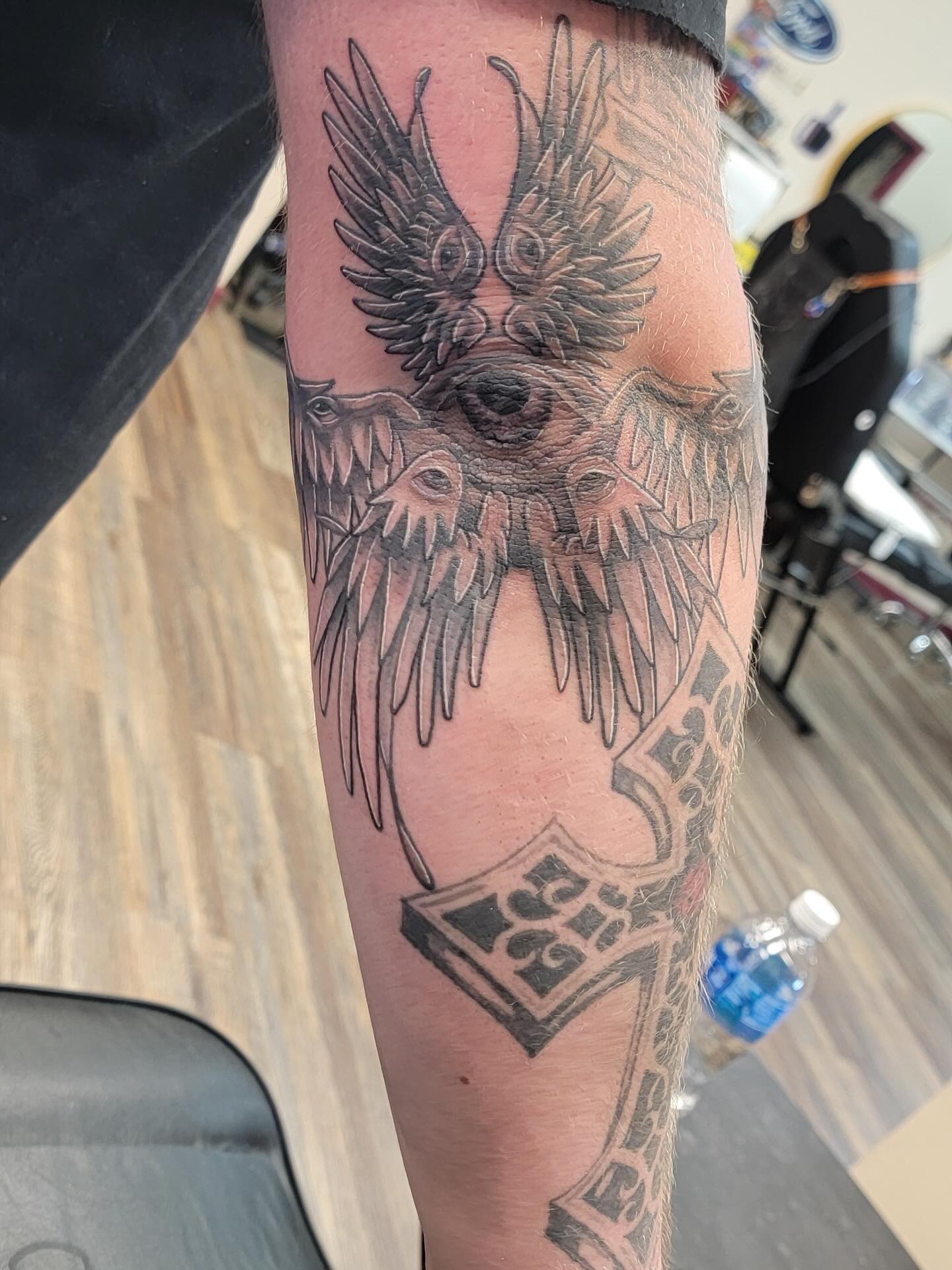 Angelic creature with wings and eyes tattoo on the forearm by Hatchetfoot Art