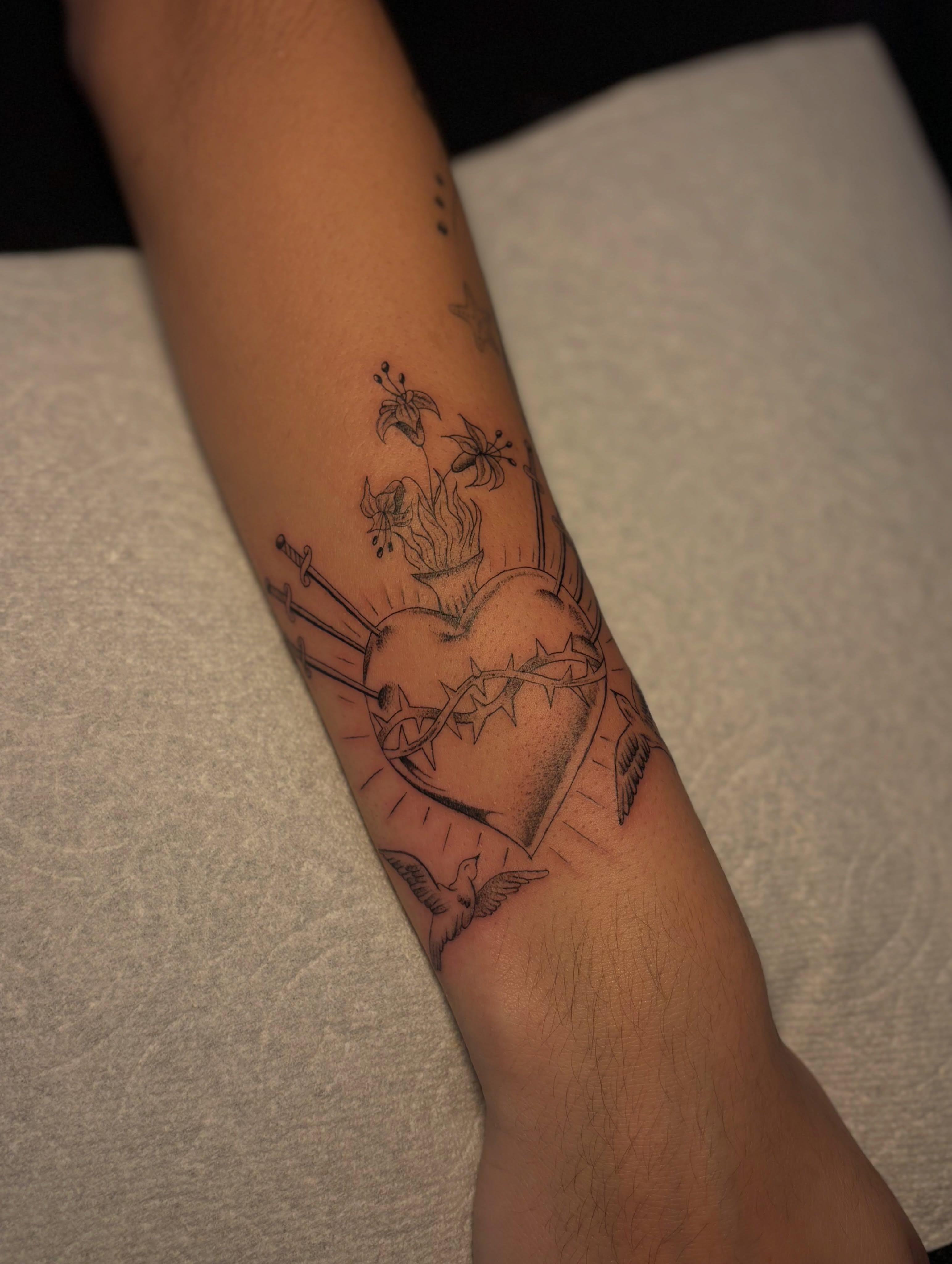 Heart with swords black and grey tattoo on the forearm by the ink witch ๐ฎ๐ค๐