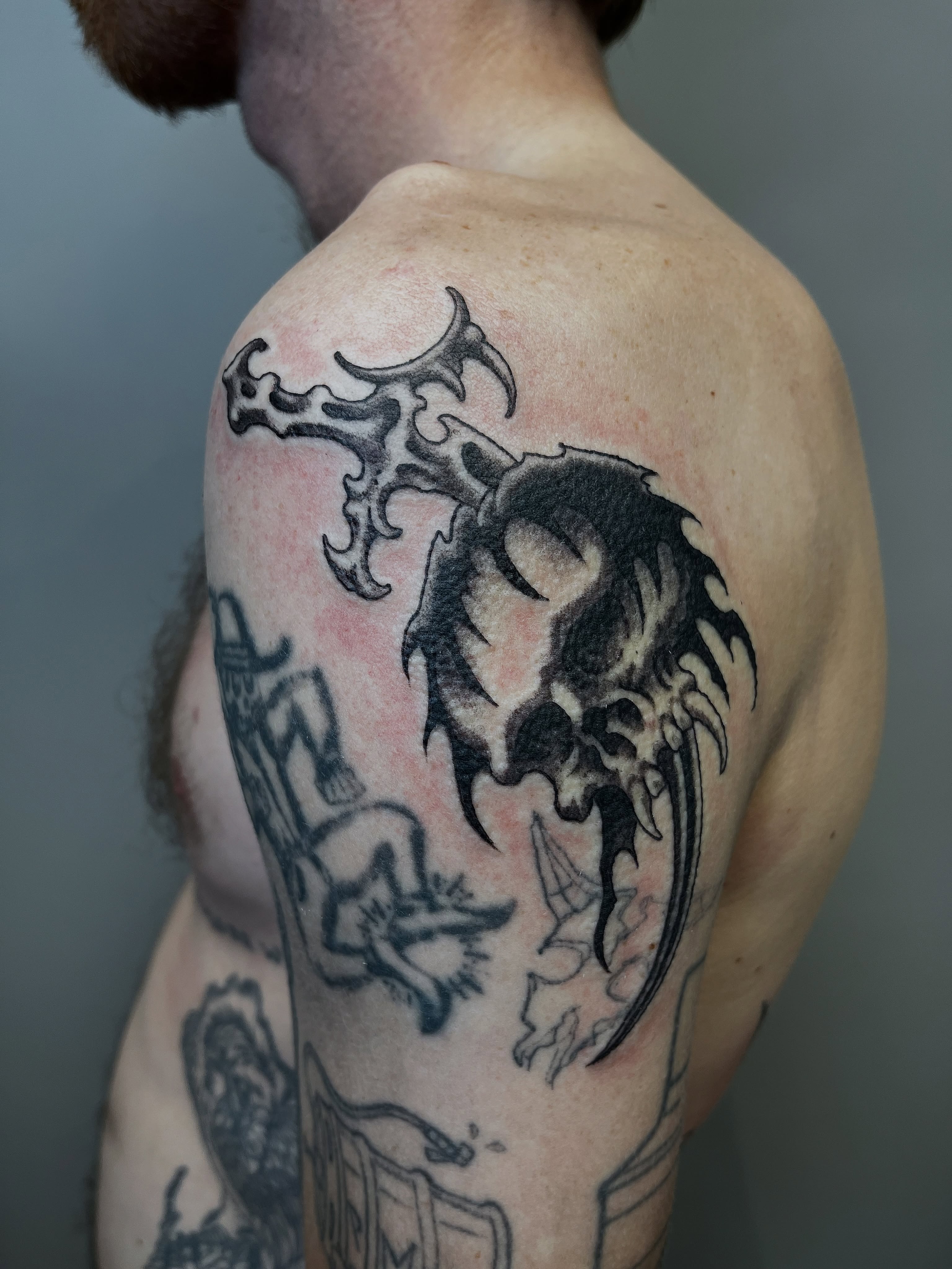 Skull with horns dark realism tattoo on the shoulder by Campbell Zane Alexander