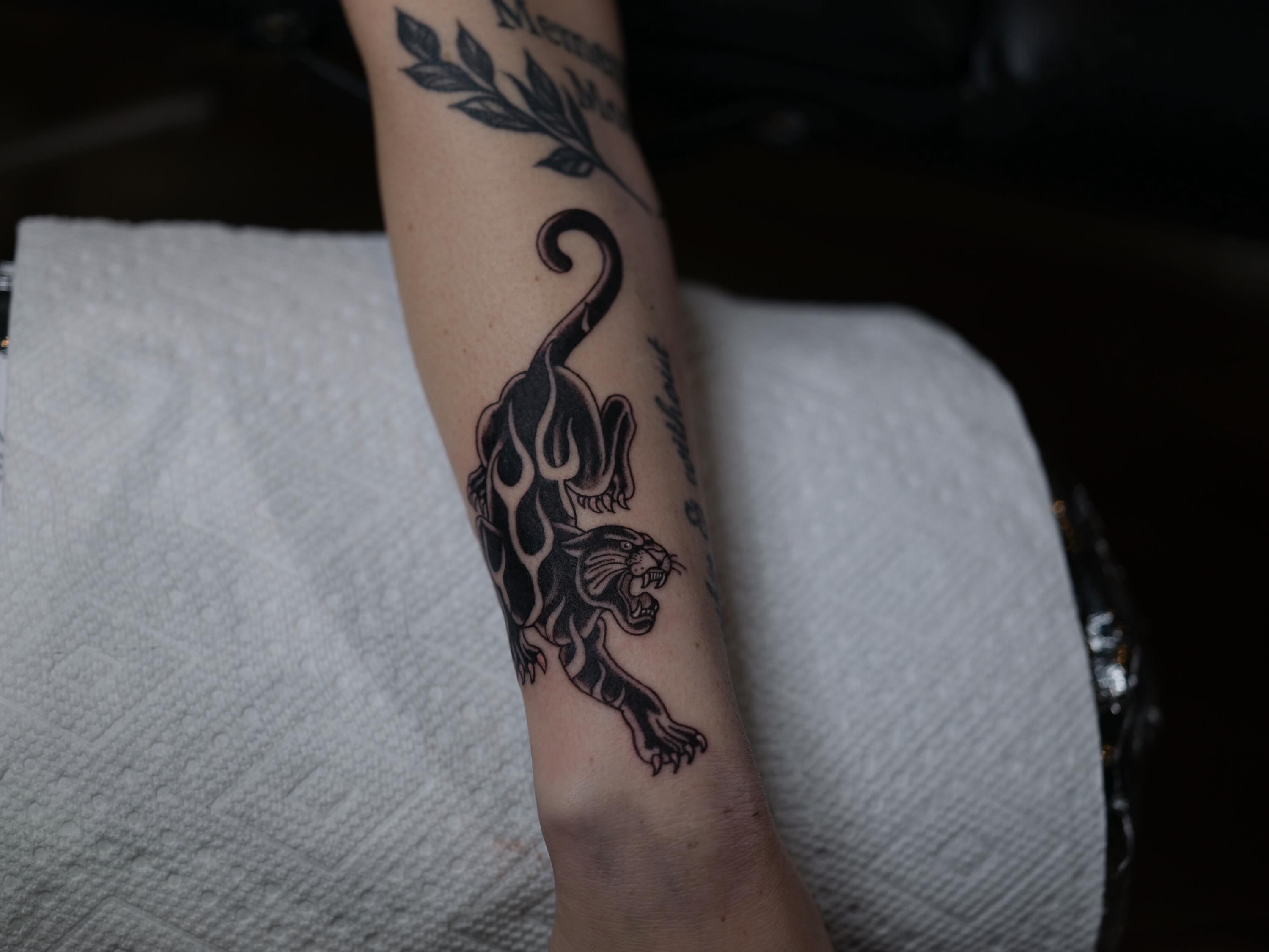 Panther black and grey tattoo on the forearm by Dylan Coverdale