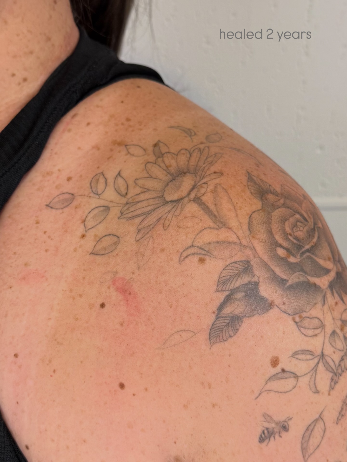 Flower and bee black and grey tattoo on the shoulder by Justin Turkus