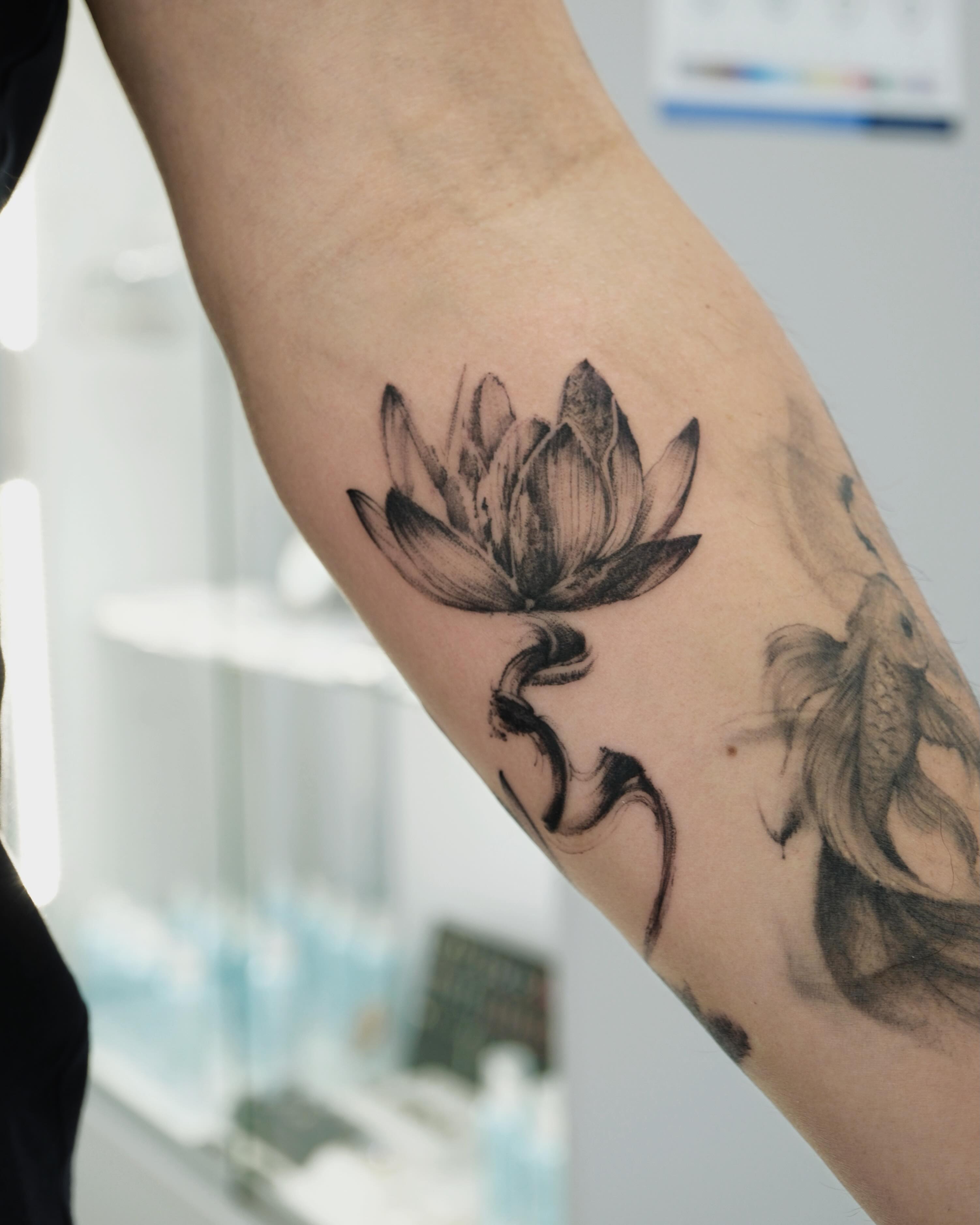 Lotus flower black and grey tattoo on the forearm by MJ tattooist