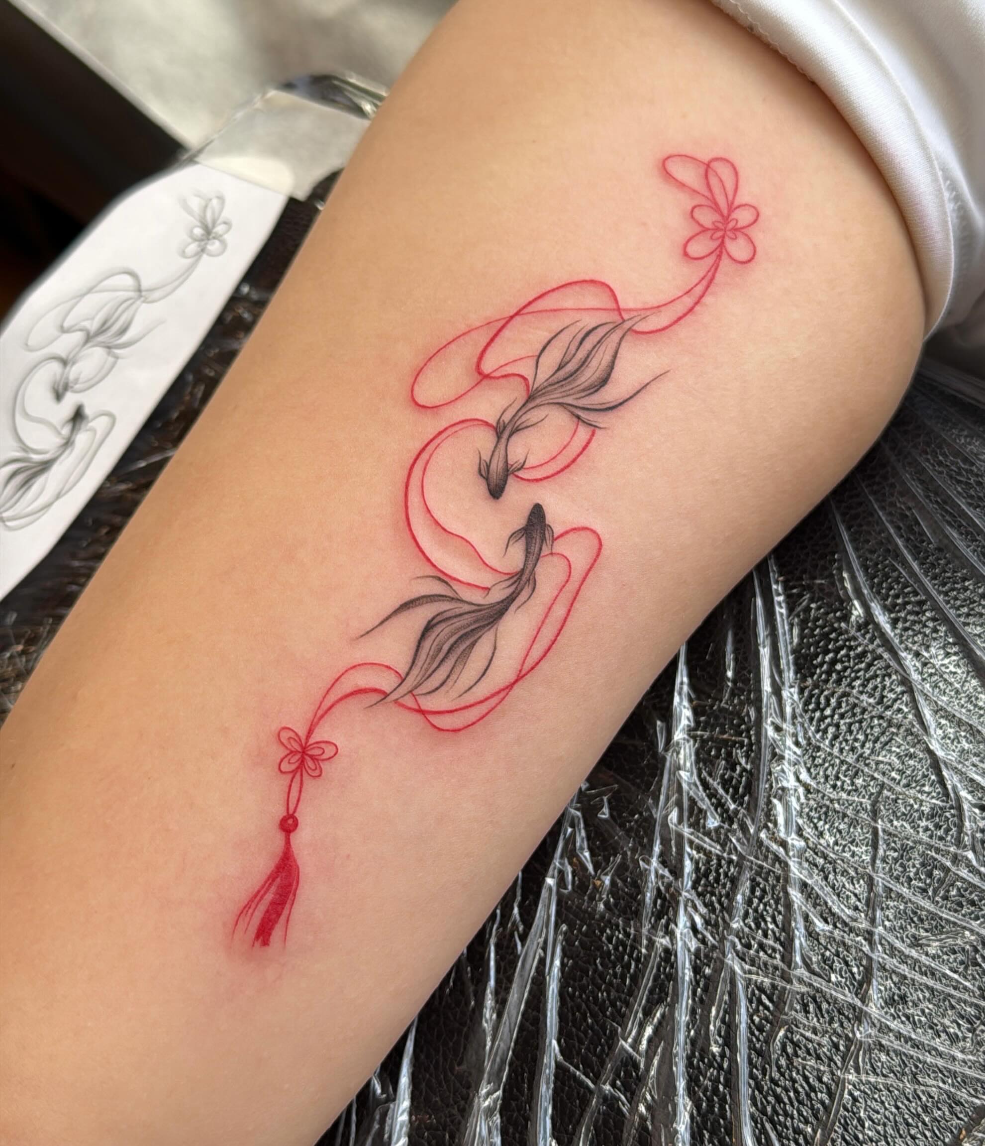 Peacock and floral fine line tattoo on the forearm by Ethan