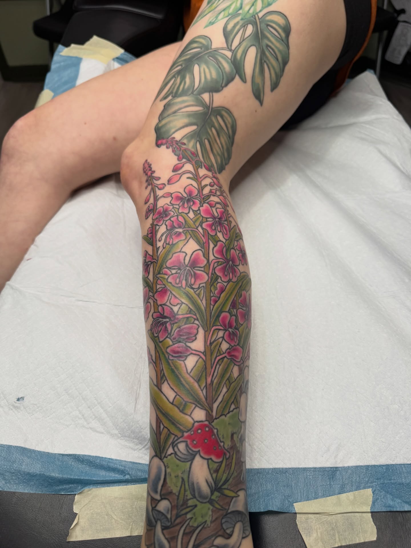 Orchids and mushrooms new school tattoo on the forearm by Joel Smith, Manhattan, Kansas