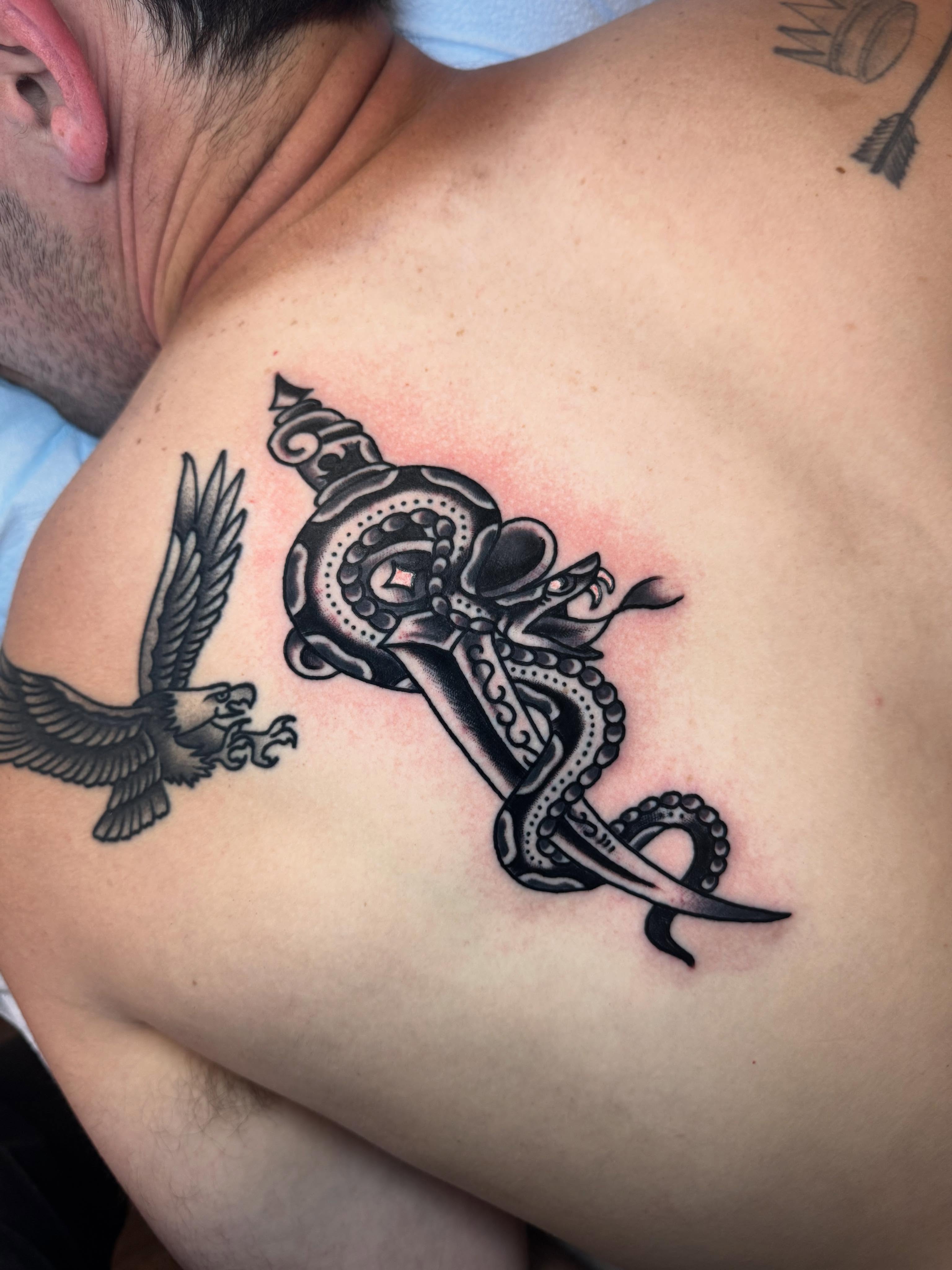 Snake and dagger black and grey tattoo on the shoulder by Jonathan Clapp, San Antonio, Texas