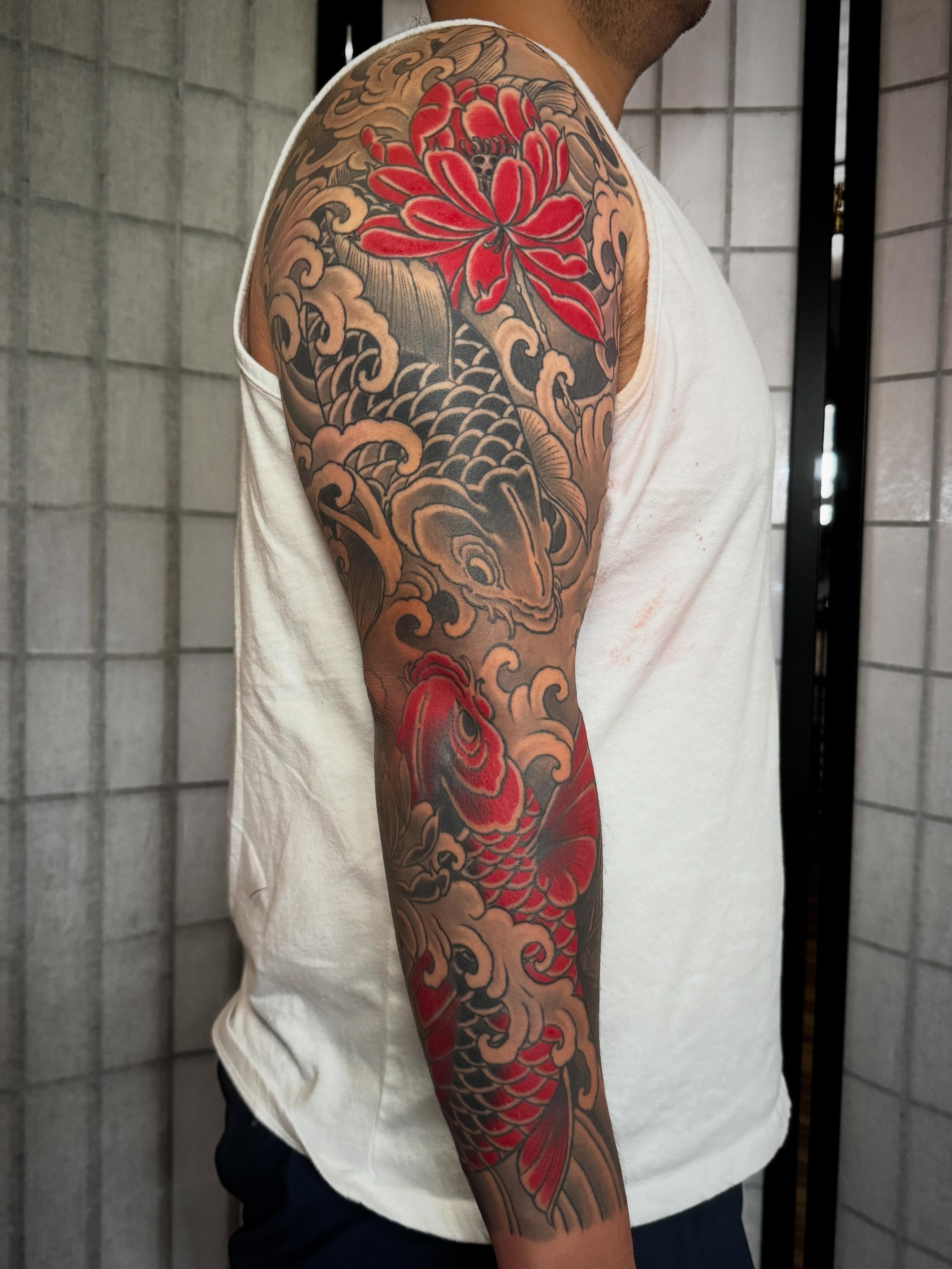 Koi fish and lotus flower japanese irezumi tattoo on the upper arm by Tattooer by Trade Wannabe Artist at Heart