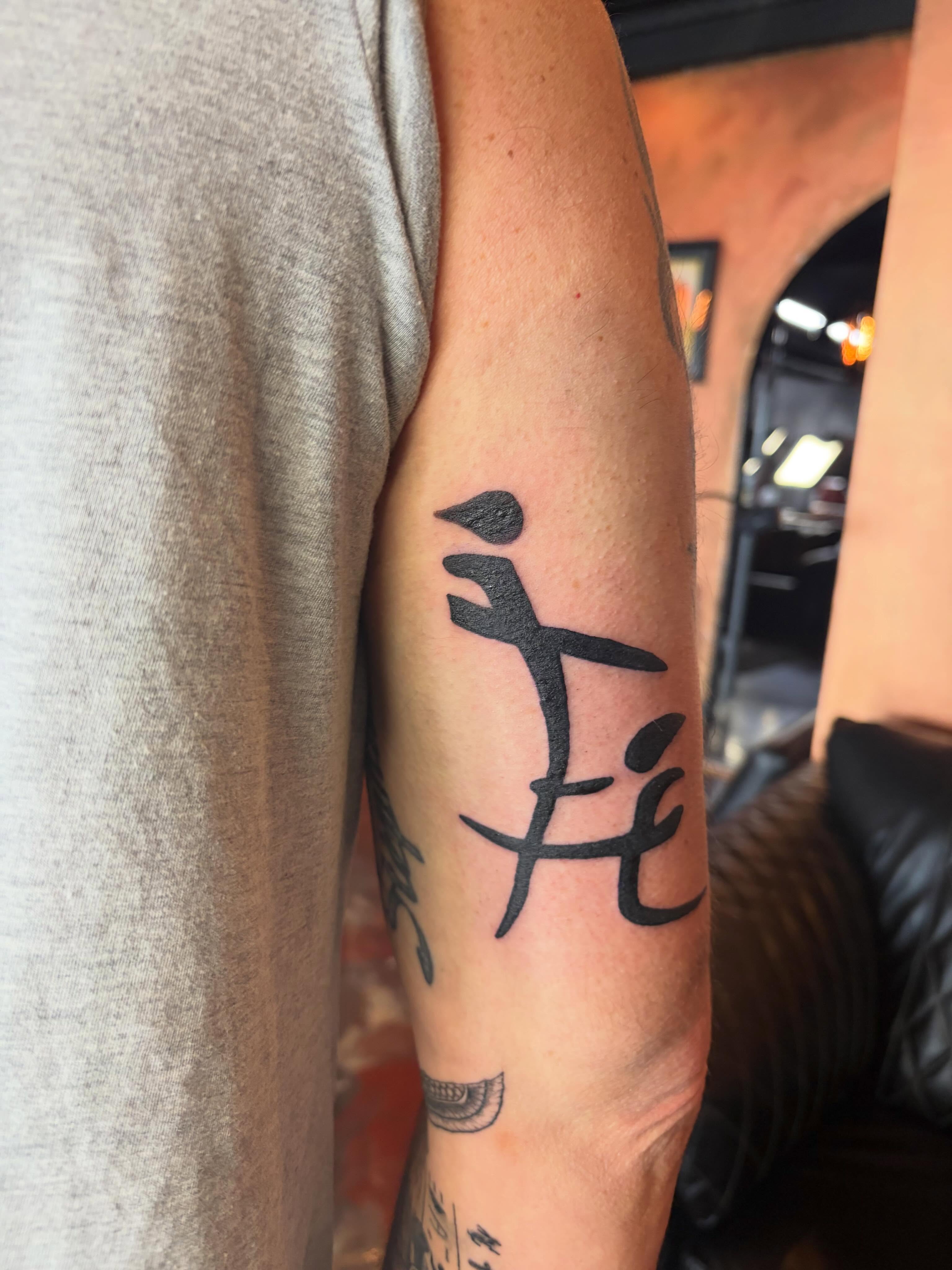 Kanji character black and grey tattoo on the forearm by destany aguilera, Davenport, Iowa