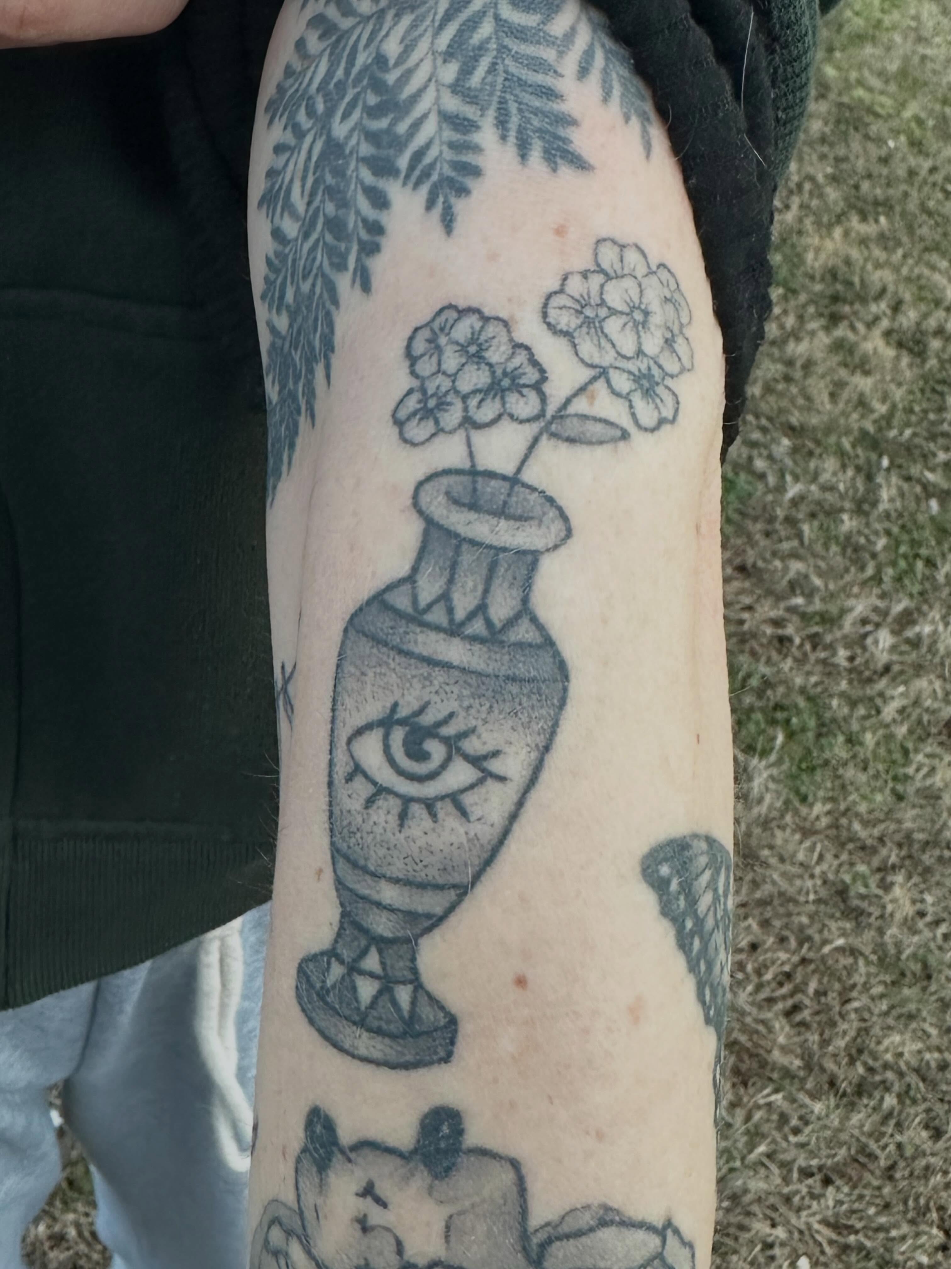 Urn with flowers black and grey tattoo on the forearm by Chi, Charlotte, North Carolina