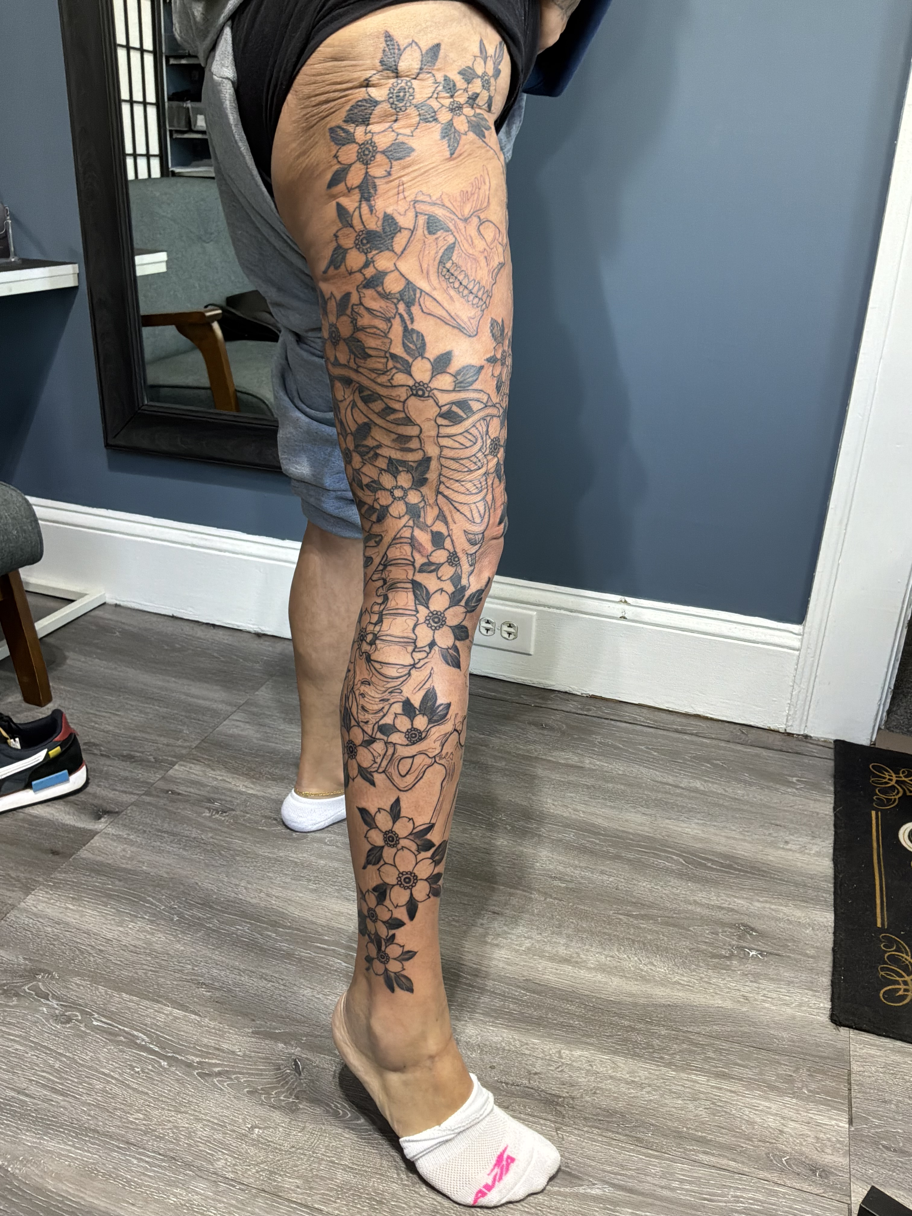 Floral and skull black and grey tattoo on the calf by German Romero-Rendon