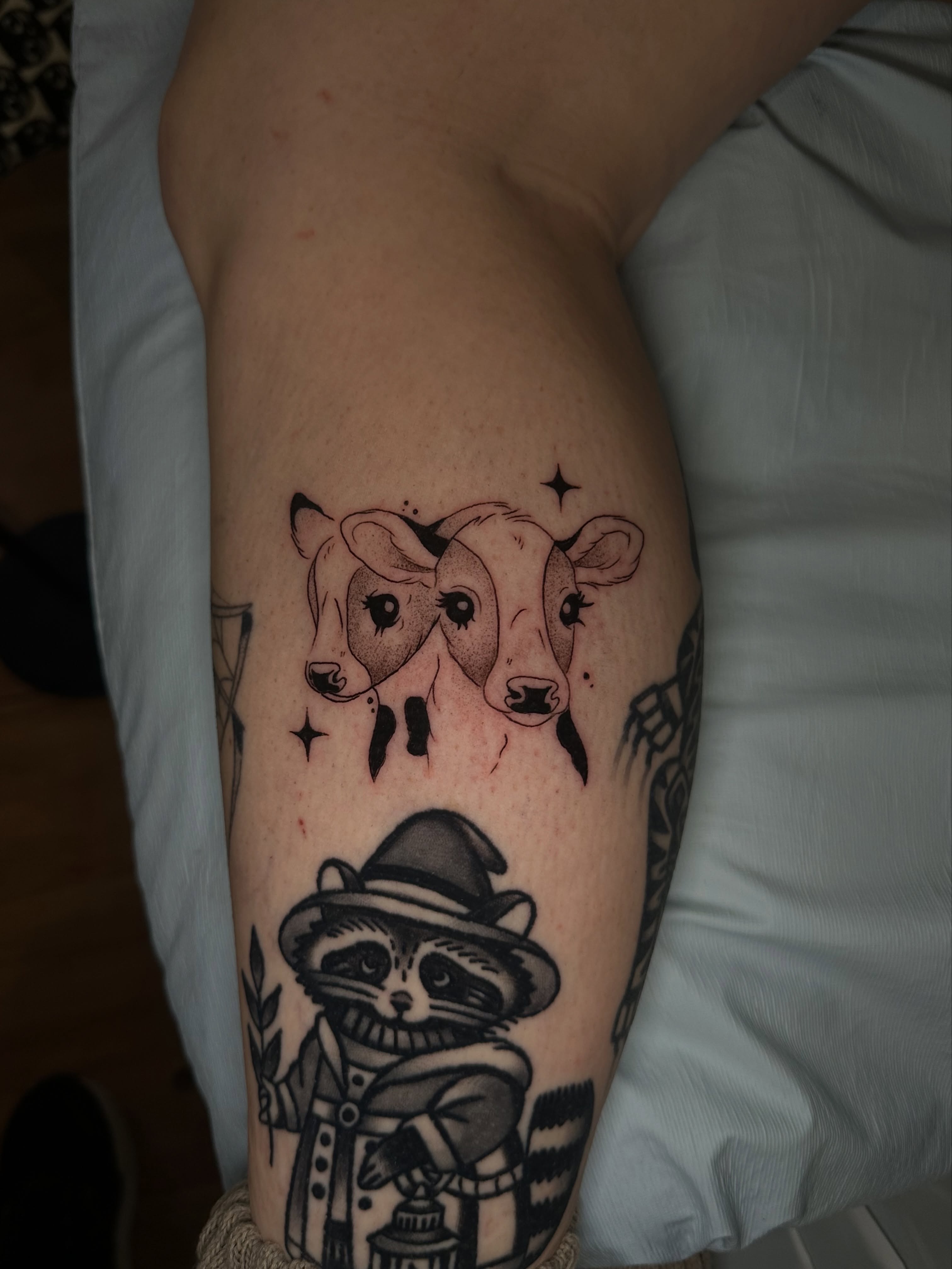 Raccoon and cows black and grey tattoo on the thigh by Yassin alsaje
