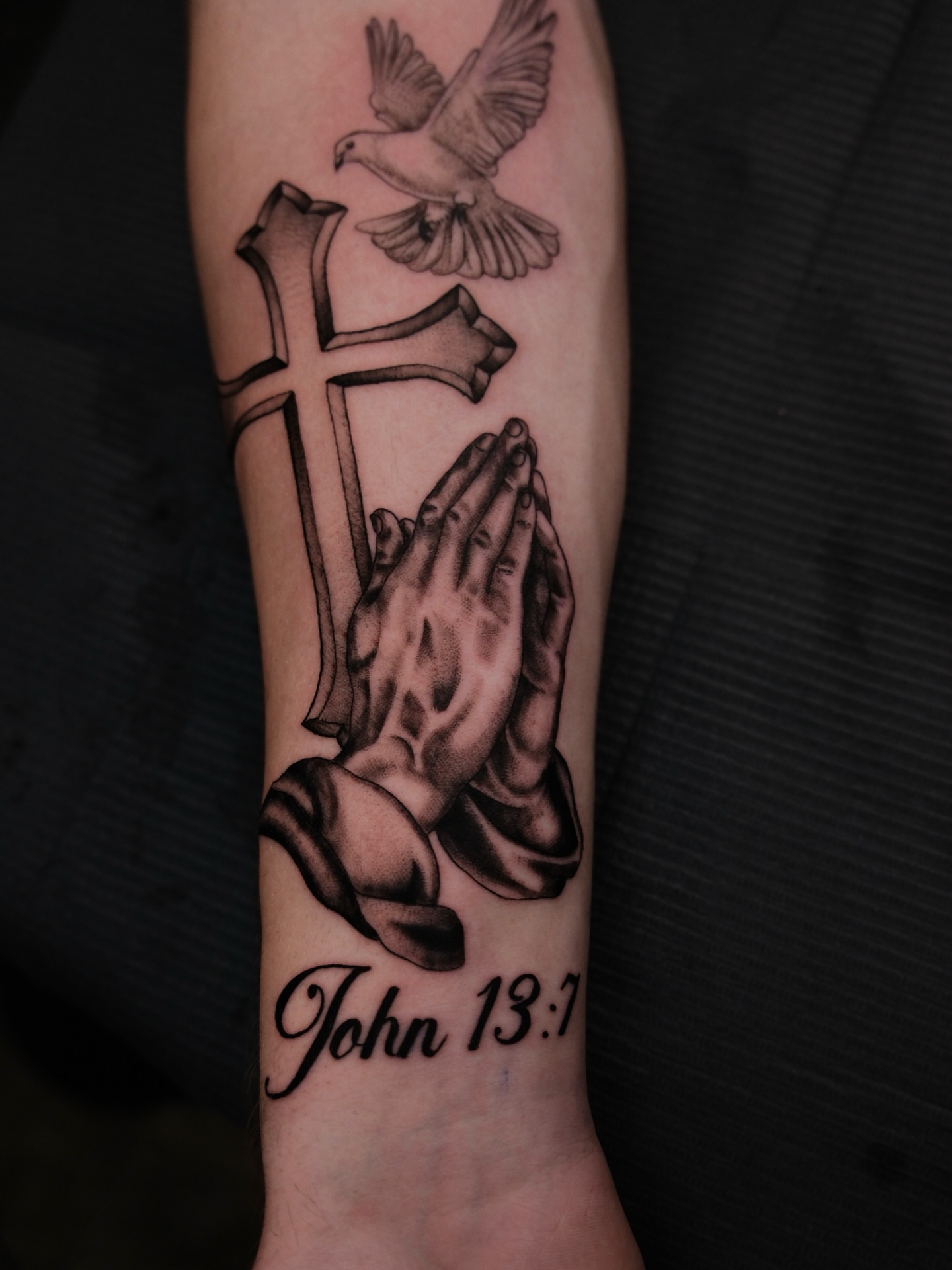 Praying hands and cross realism tattoo on the forearm by Kiana Hope