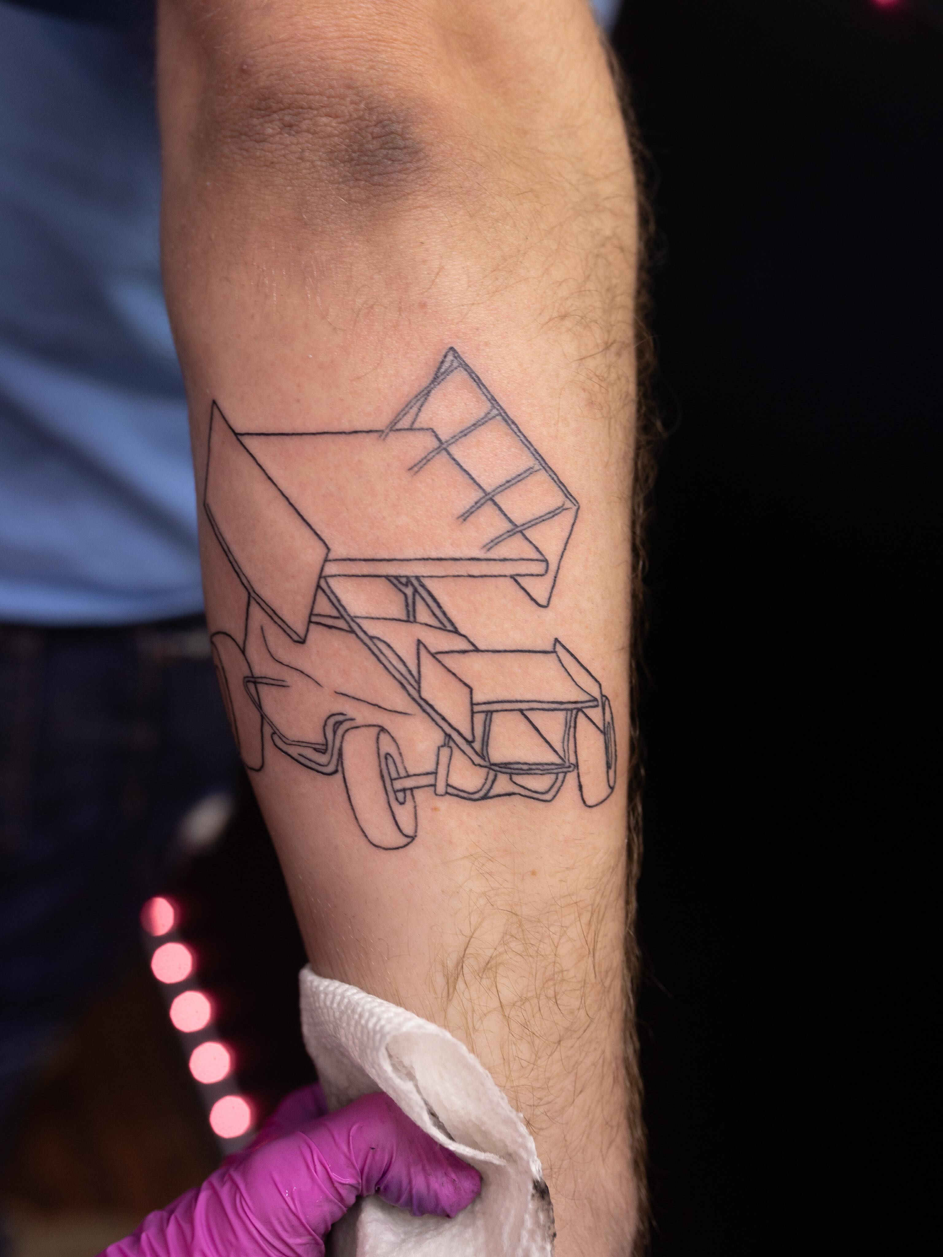 Race car geometric tattoo on the forearm by Kelsie