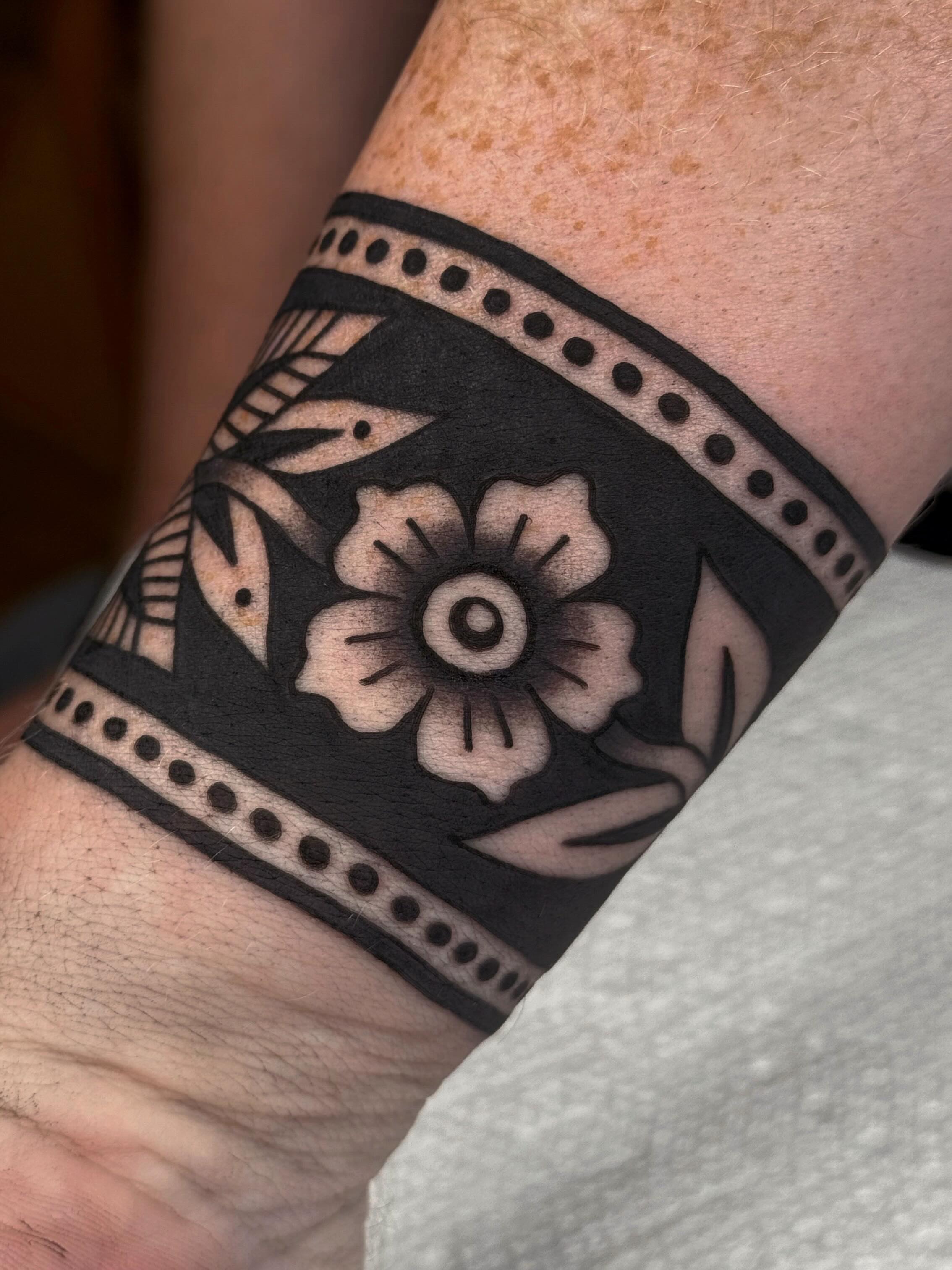 Flower black and grey tattoo on the forearm by Bridgette Carberry