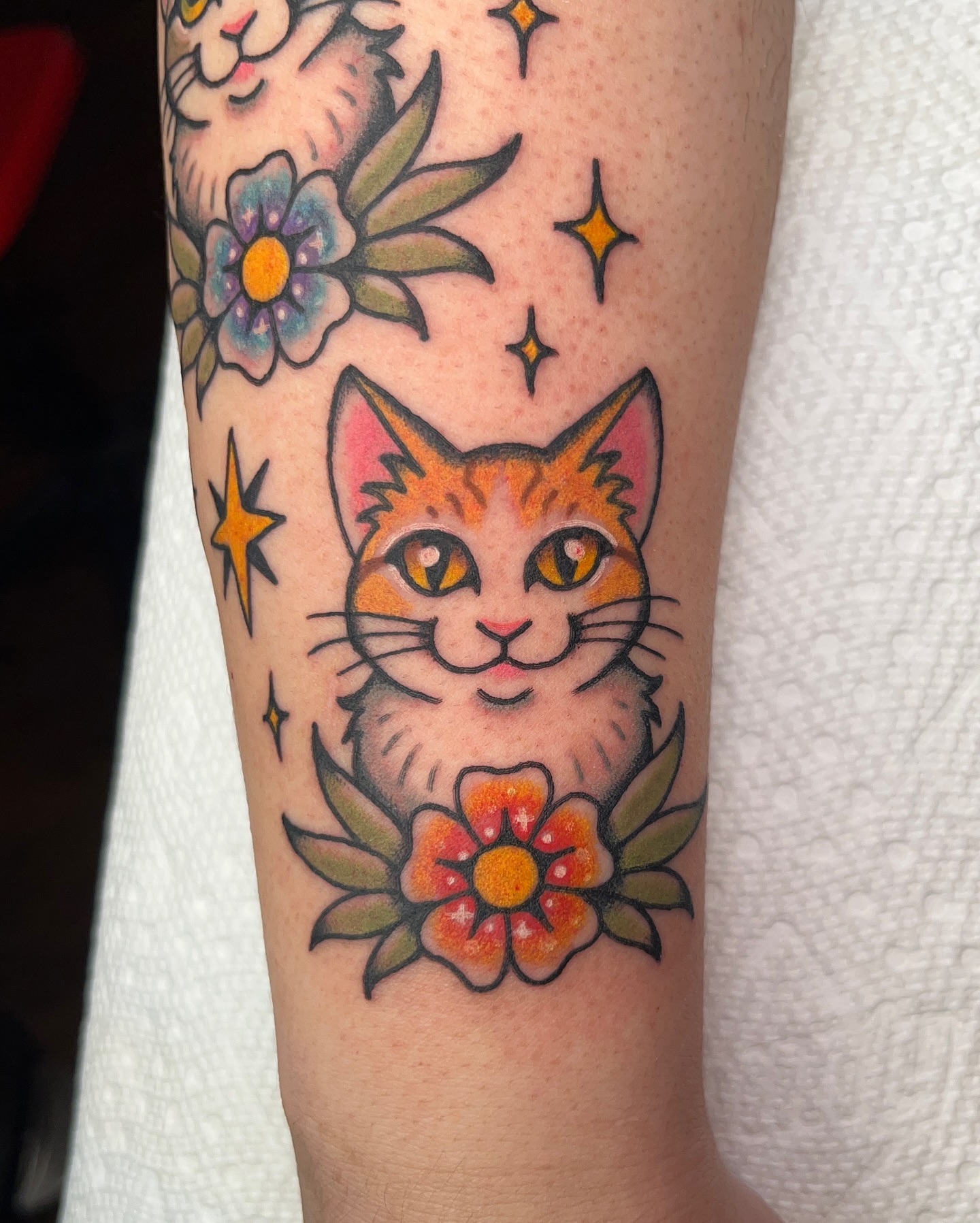 Cat and flower American traditional tattoo on the forearm by Nat Power
