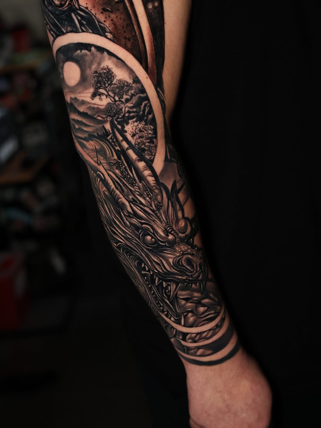 Dragon head with landscape scene Japanese tattoo on the forearm by Insight Ink Tattoo
