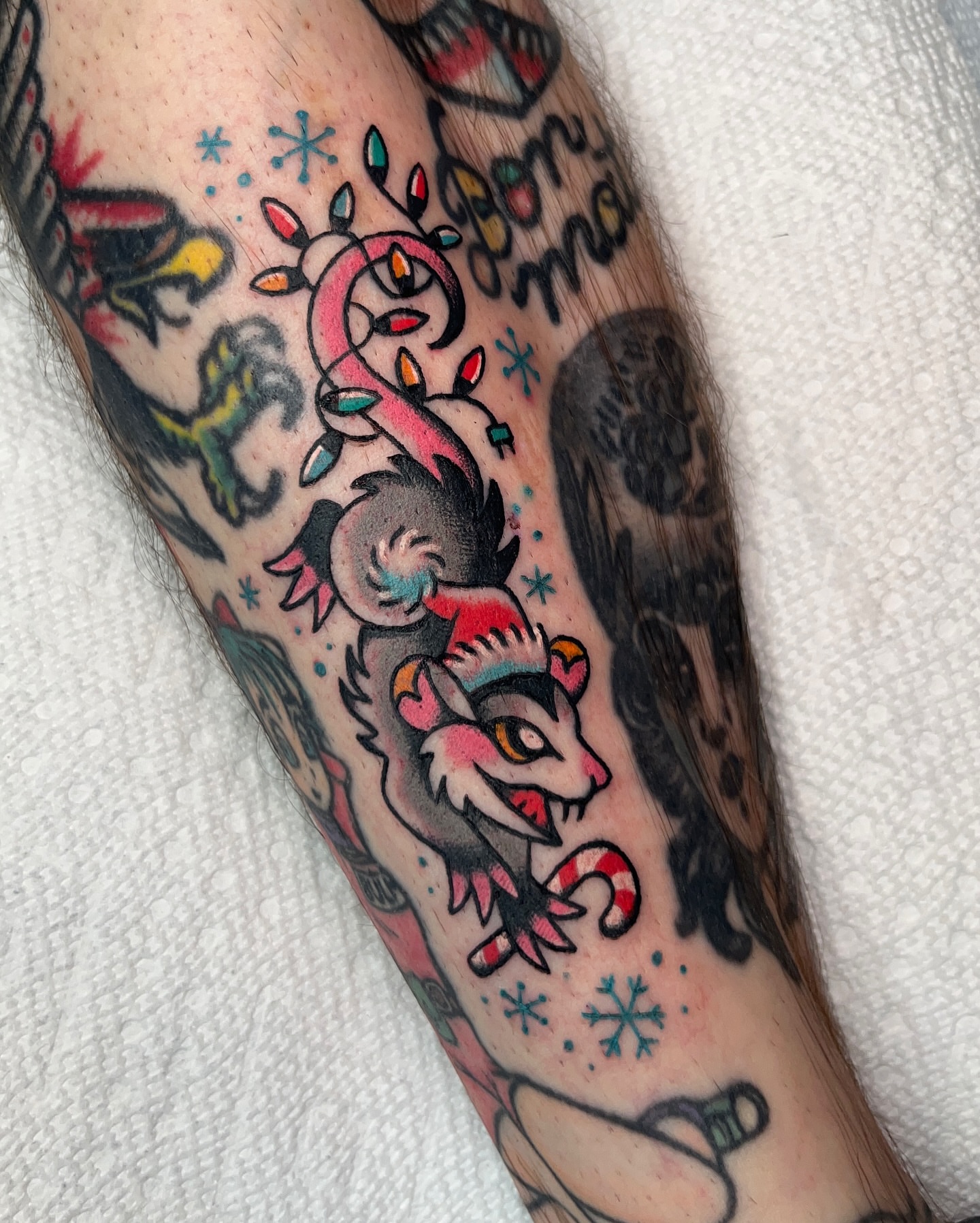 Reindeer with candy cane American traditional tattoo on the forearm by Nat Power