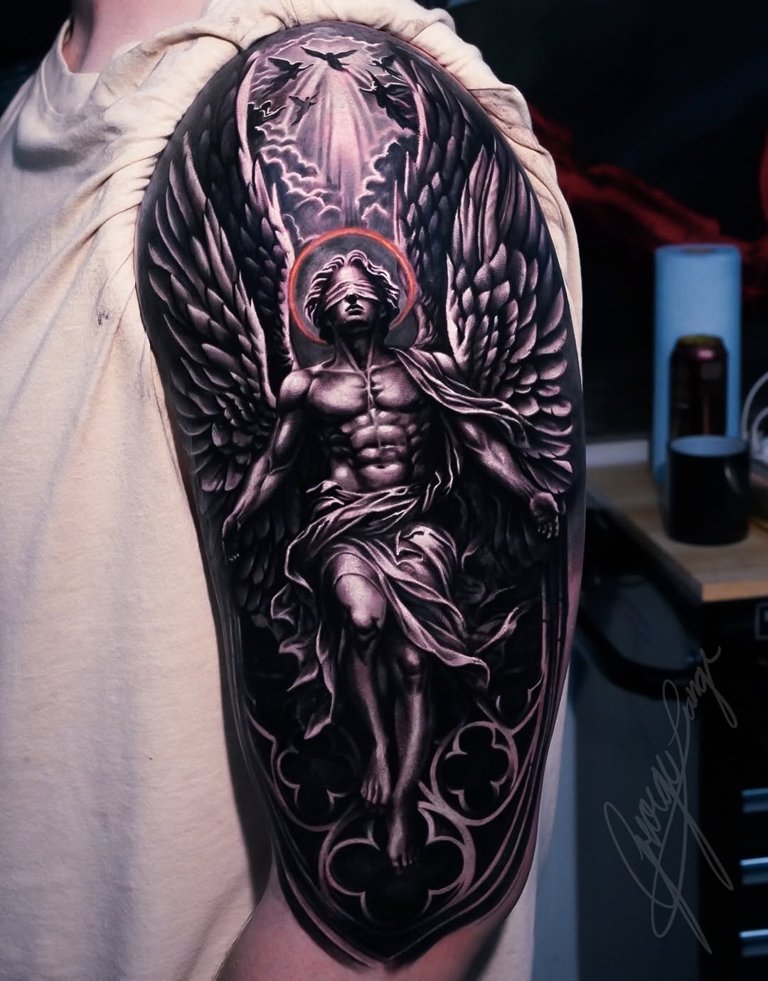 Angel with blindfold and wings realism tattoo on the upper arm by George Lange