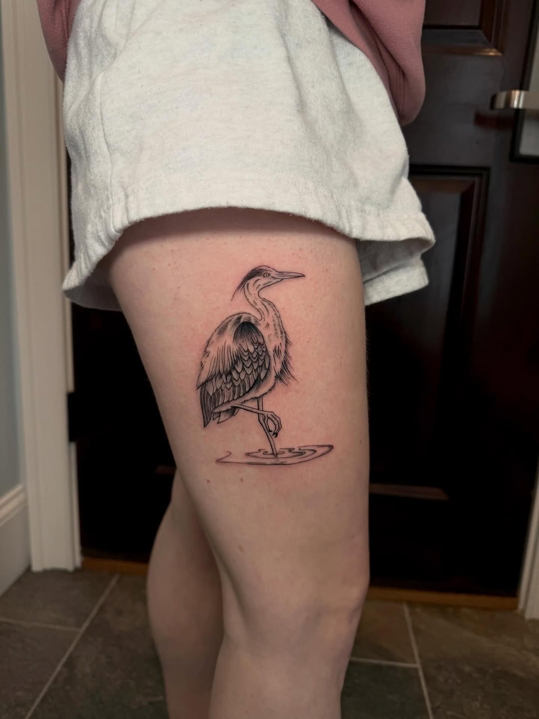 Heron standing in water fine line tattoo on the thigh by Ana Blatt