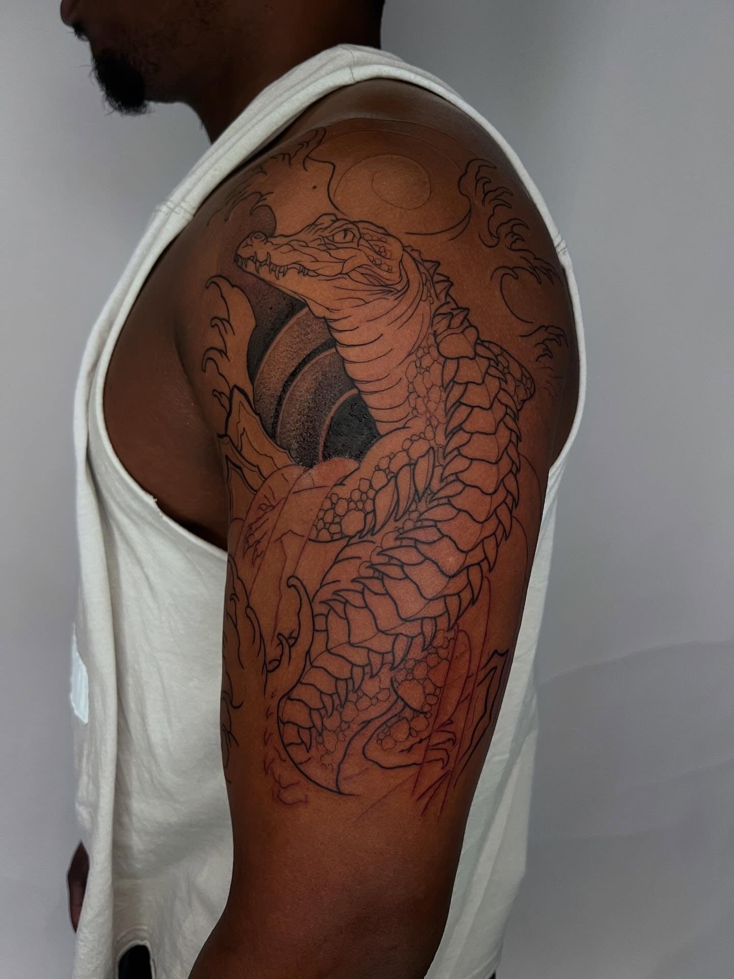Crocodile dotwork tattoo on the shoulder by Dolph.