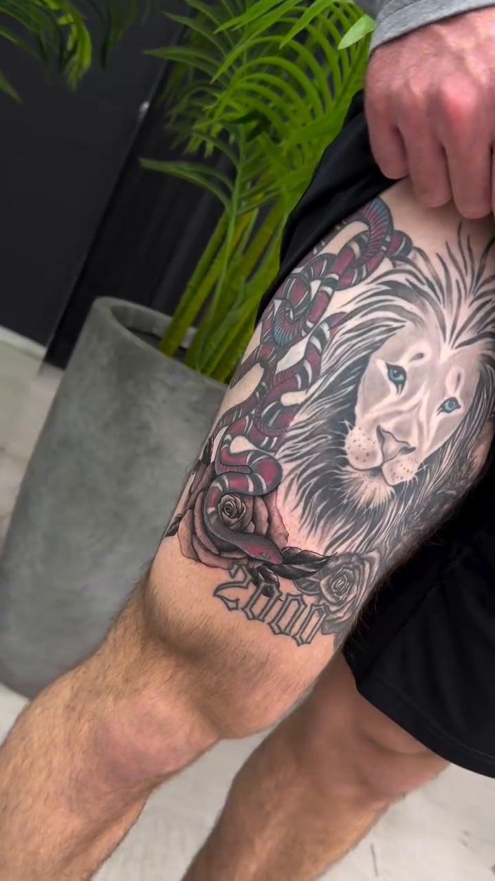 Lion and snake with roses realism tattoo on the upper arm by Lina Valentina, New York, New York