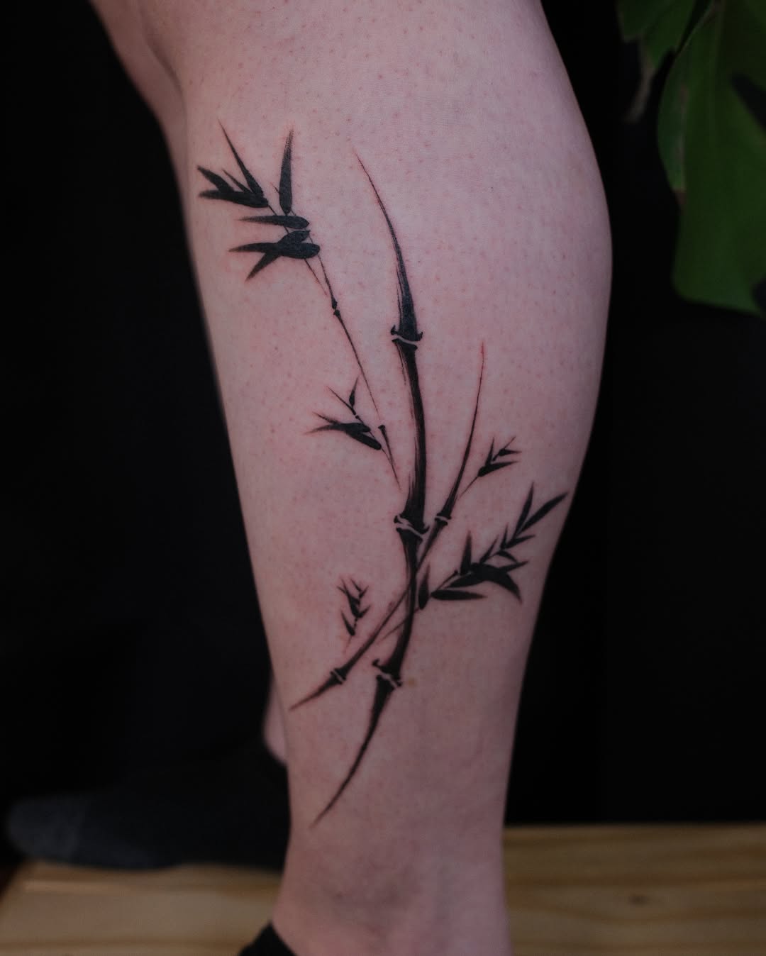 Bamboo branch blackwork tattoo on the calf by lela