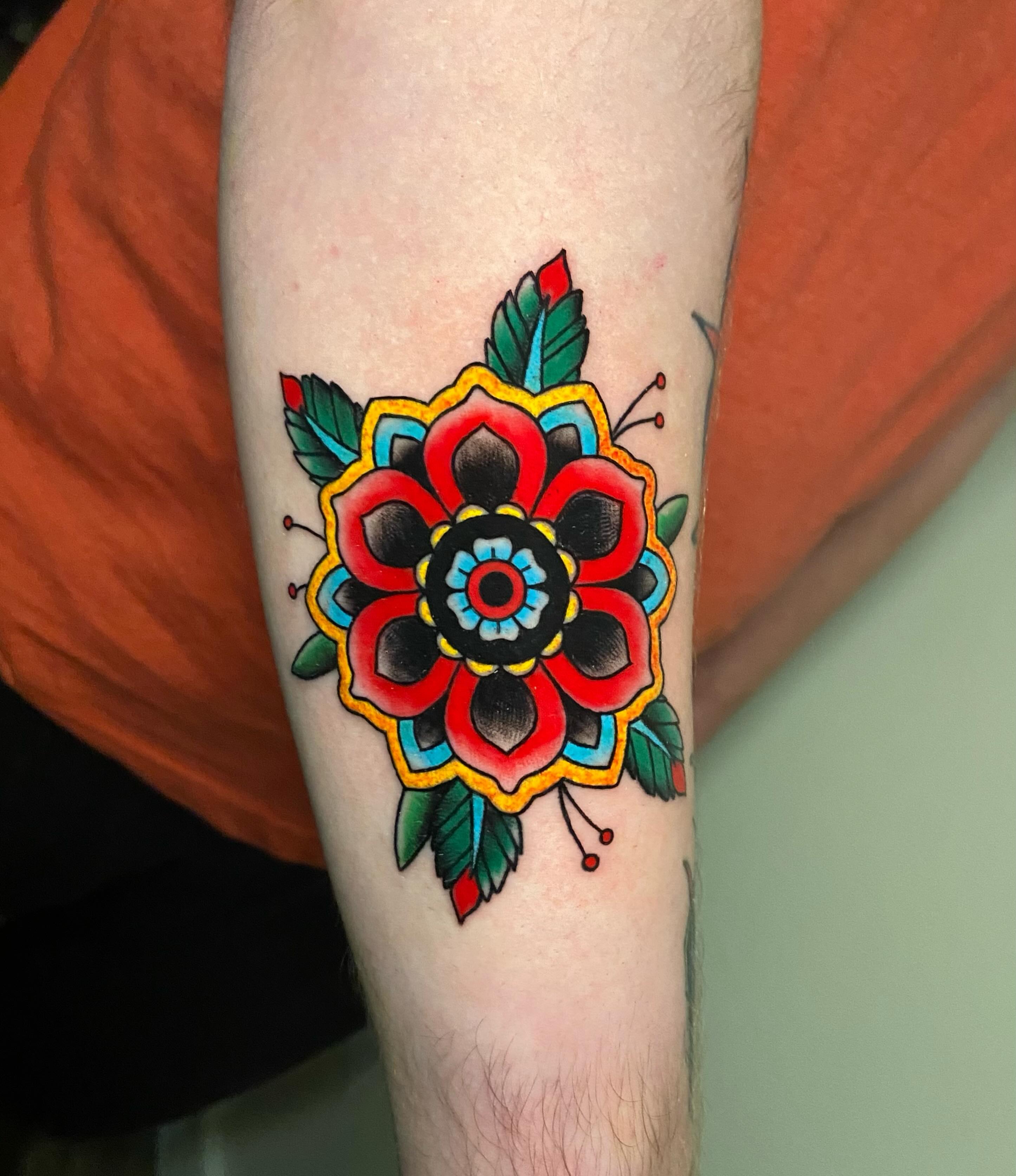 Floral design American traditional tattoo on the forearm by Ezra Gonda