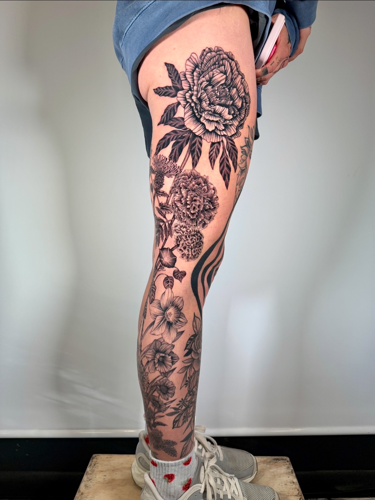 Floral bouquet black and grey tattoo on the thigh by aria, Austin, Texas