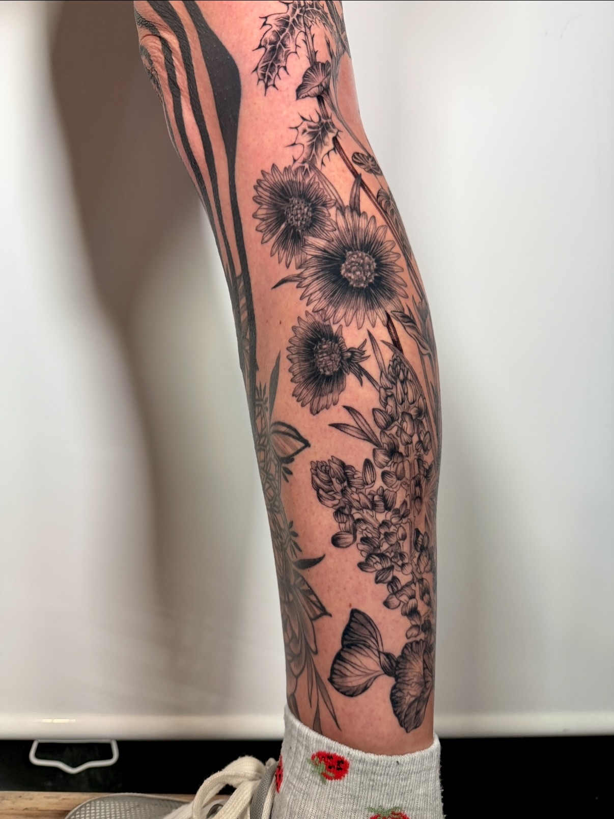 Floral arrangement black and grey tattoo on the forearm by aria, Austin, Texas