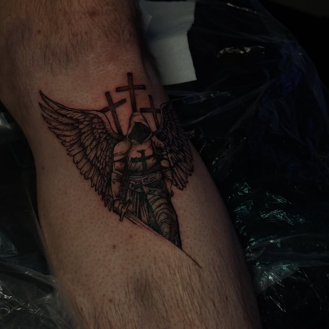 Angel with sword and crosses realism tattoo on the thigh by licensed charlotte tattoo artist