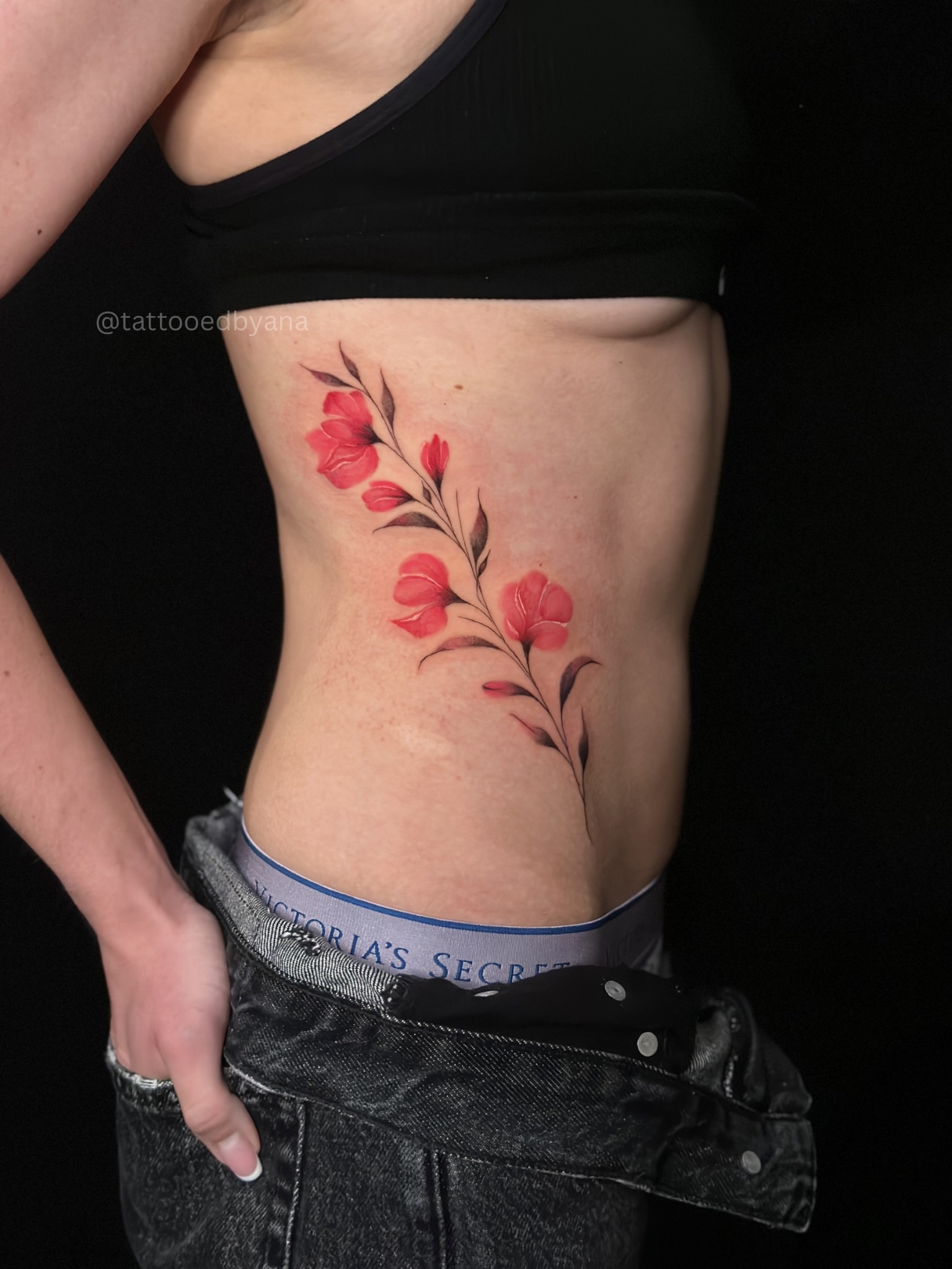 Red flowers realism tattoo on the ribs by Tattoo artist Denver
