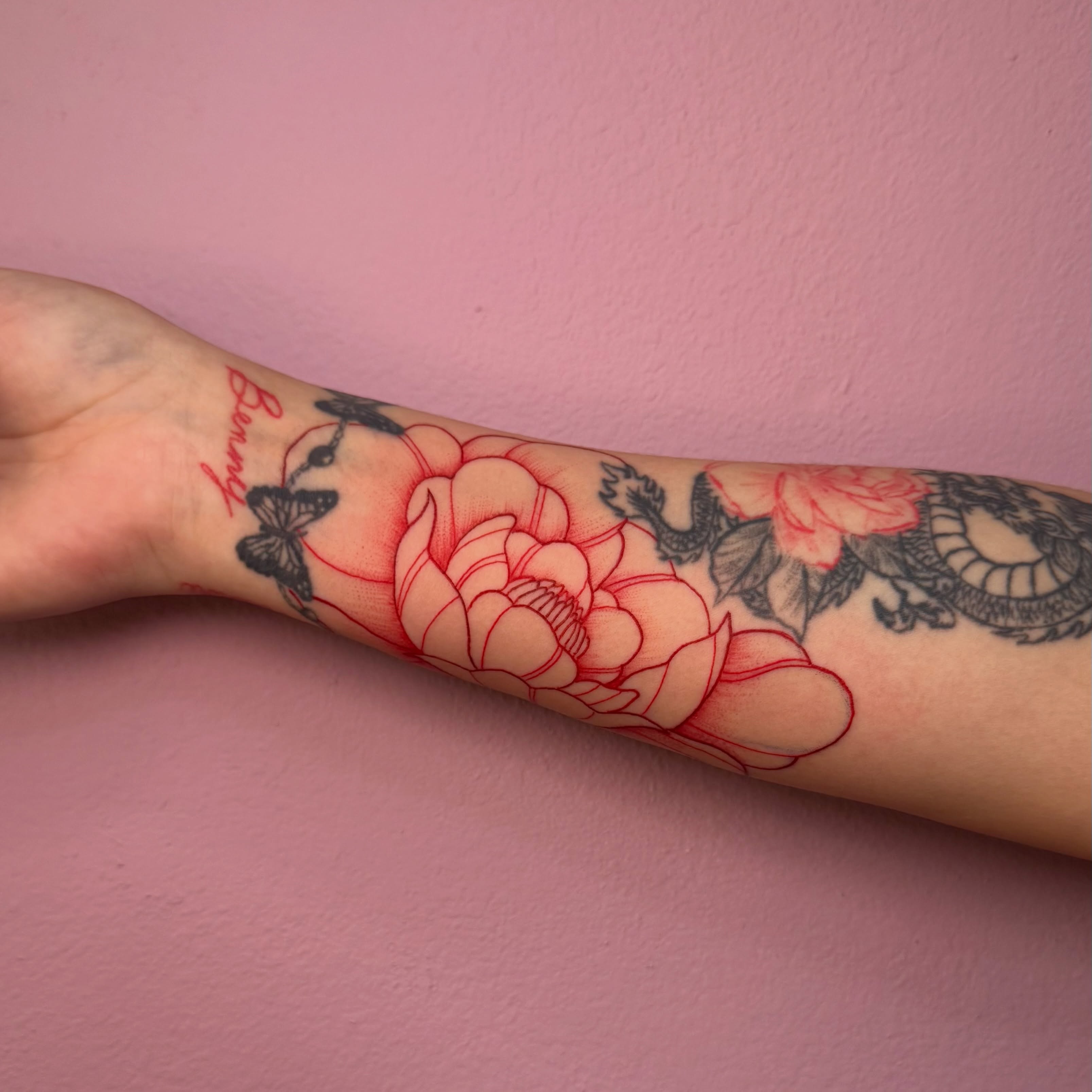 Lotus flowers and dragon American traditional tattoo on the forearm by @inkedbybanti