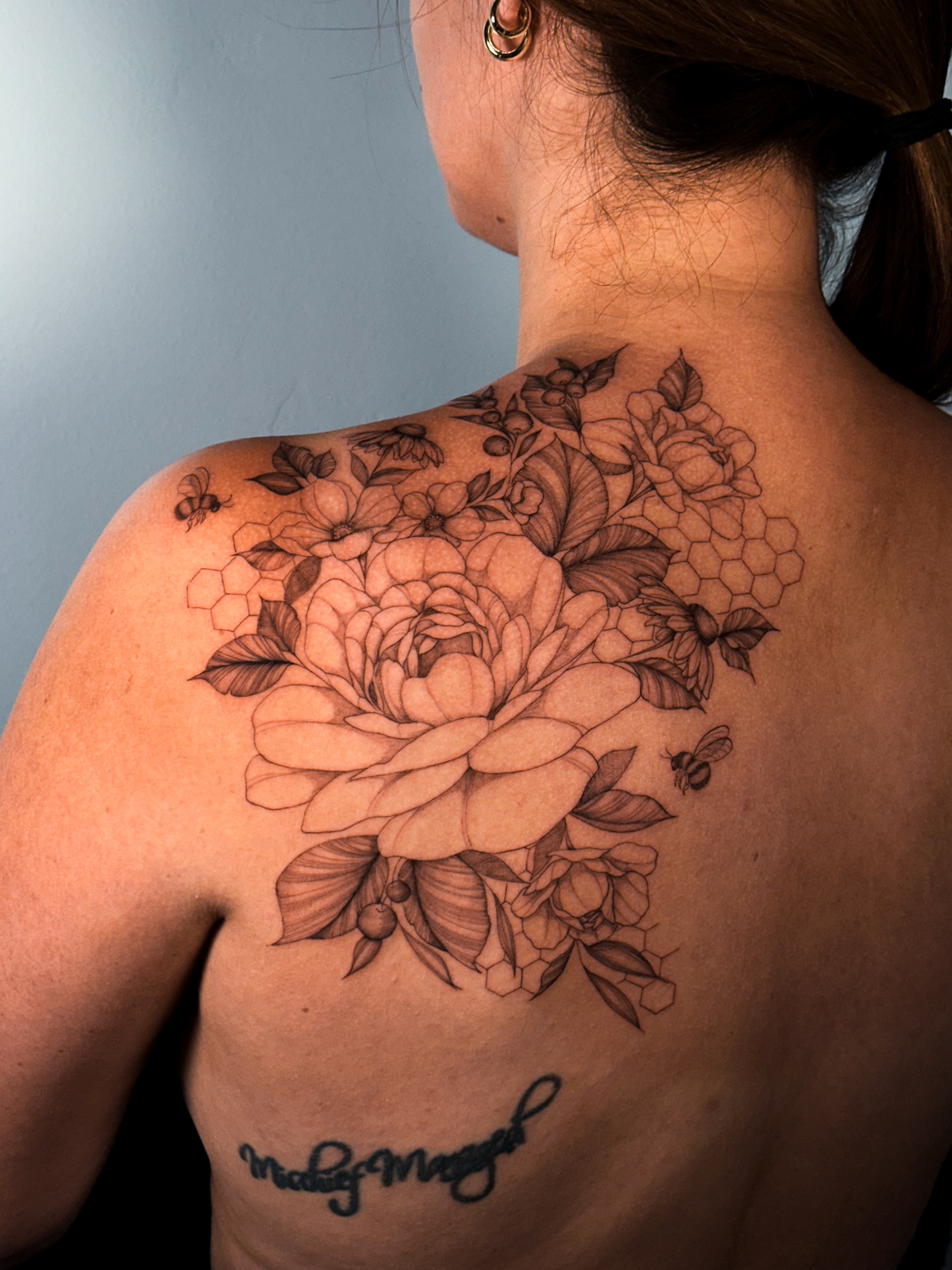 Floral bouquet realism tattoo on the back by Caroline + Utah Tattoo Artist
