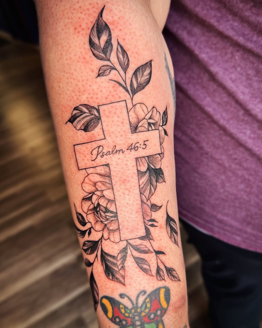 Cross with flowers and scripture tattoo on the forearm by Kate