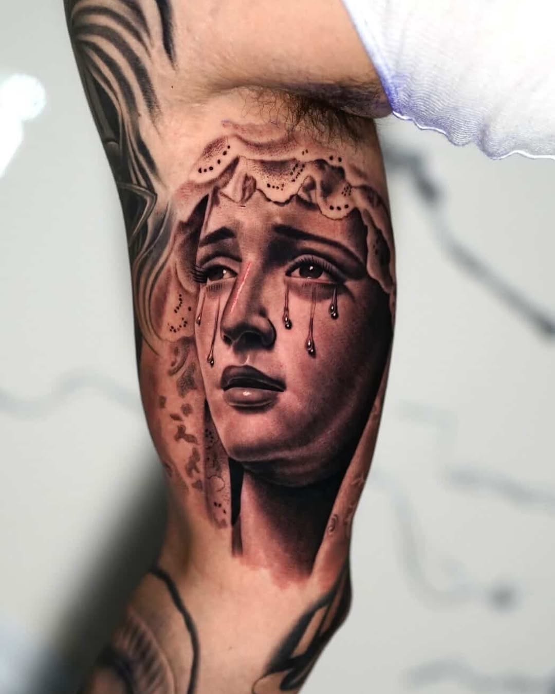 Crying woman's face Chicano tattoo on the forearm by Luis Peña