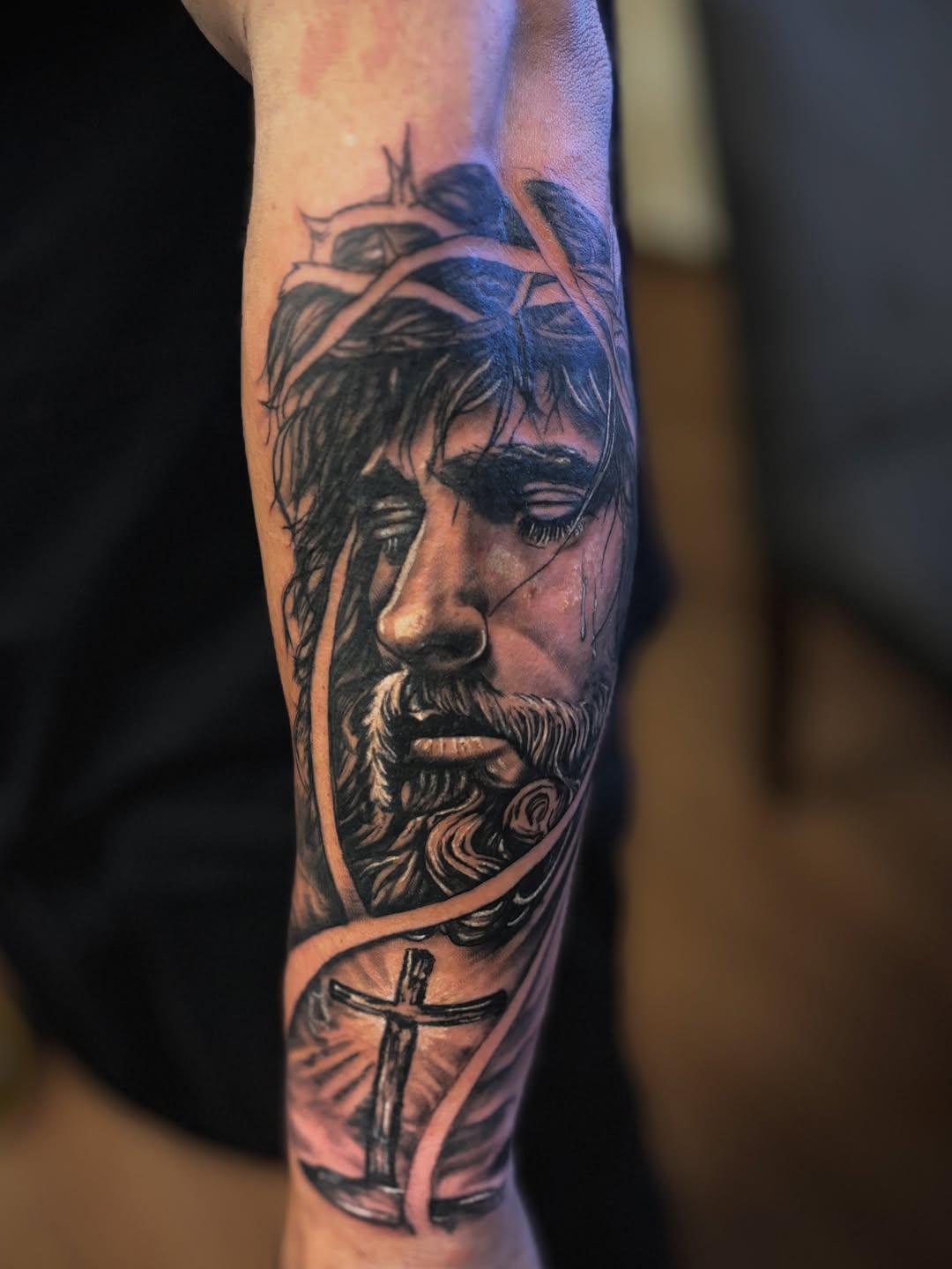Jesus Christ portrait with cross realism tattoo on the forearm by Mauricio gois