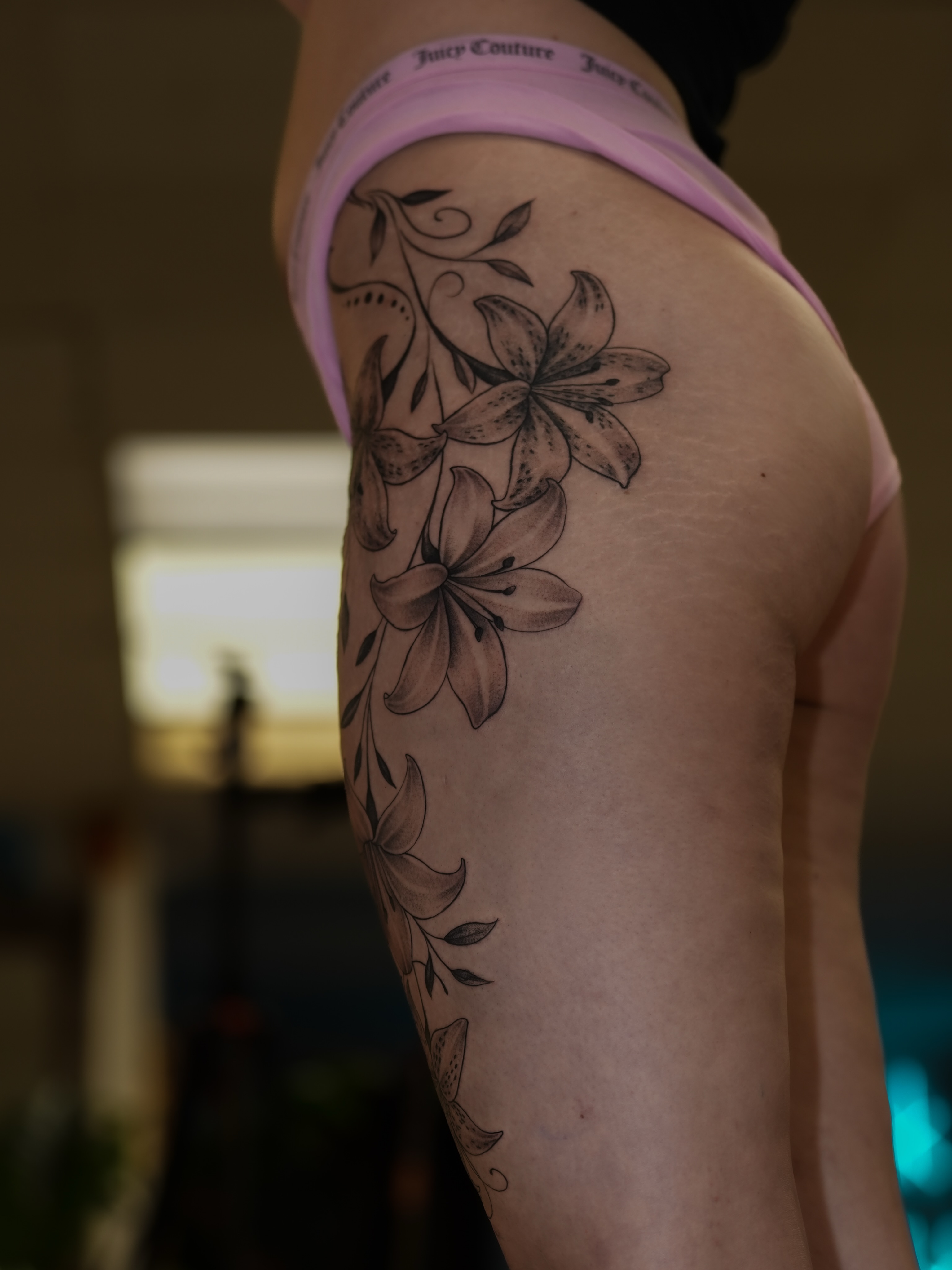 Lilies black and grey tattoo on the thigh by Kevin Betancourt