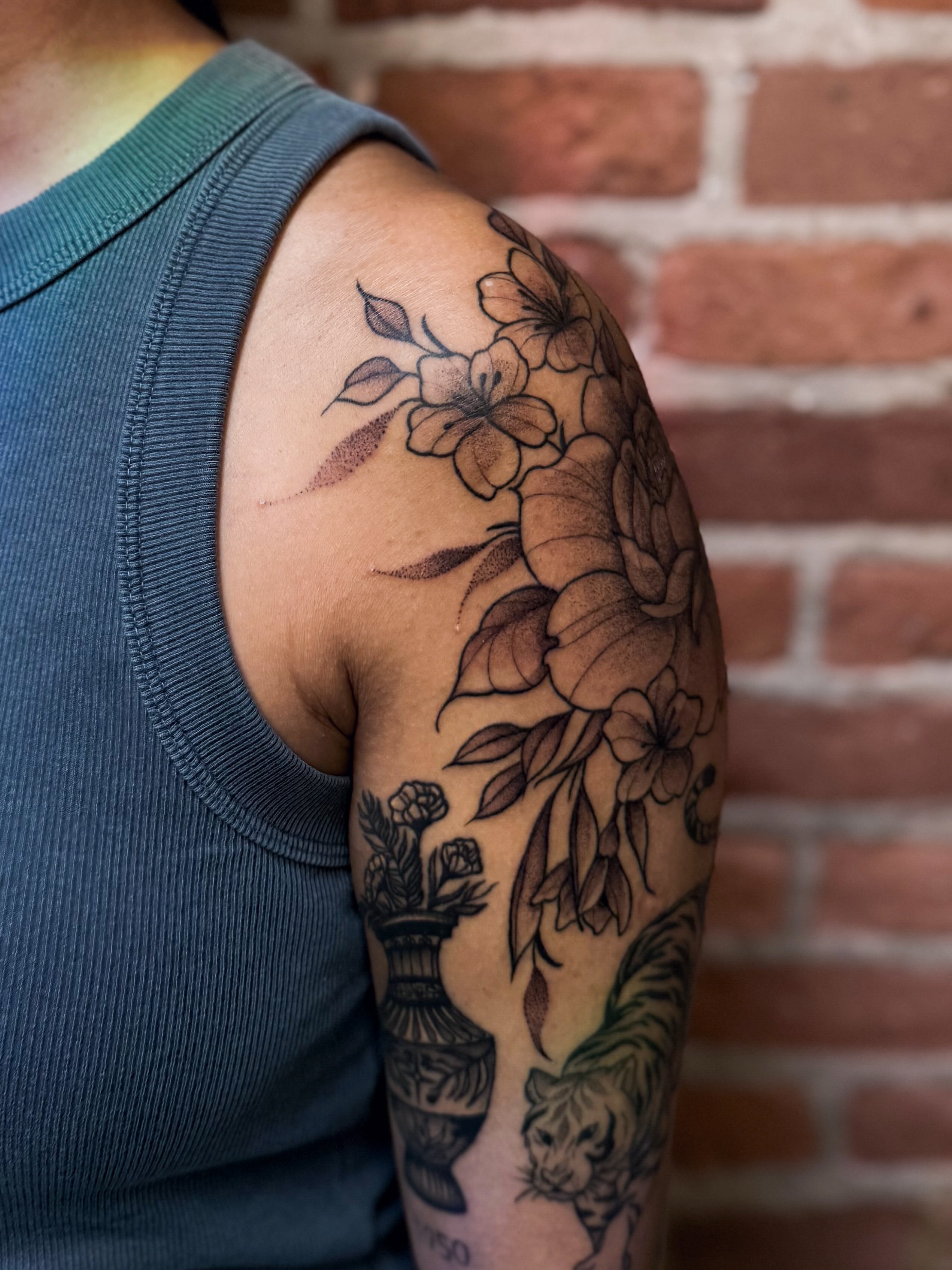 Floral arrangement black and grey tattoo on the shoulder by Jessica Bloom