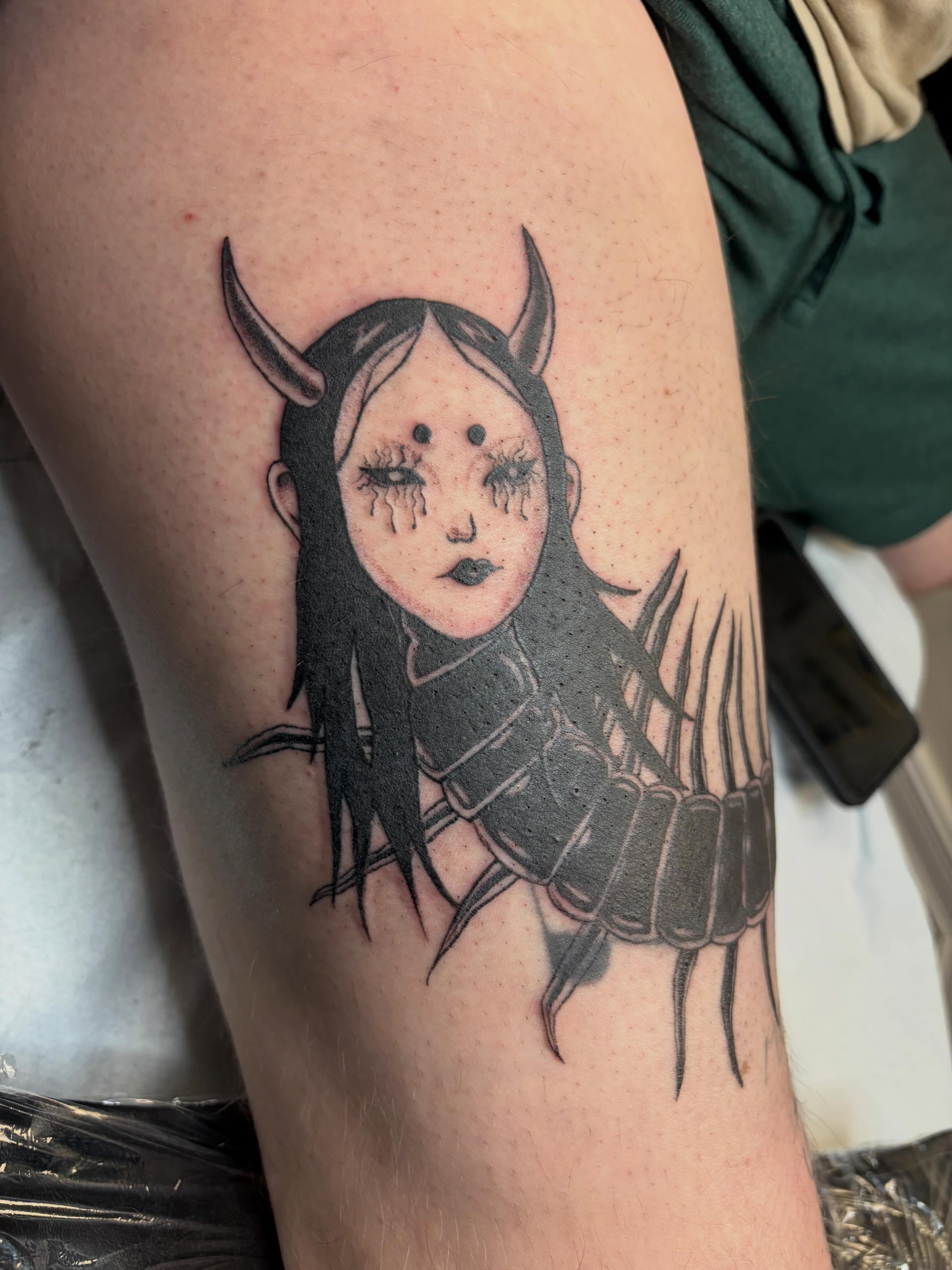 Girl with horns dark realism tattoo on the thigh by Deni Carolina