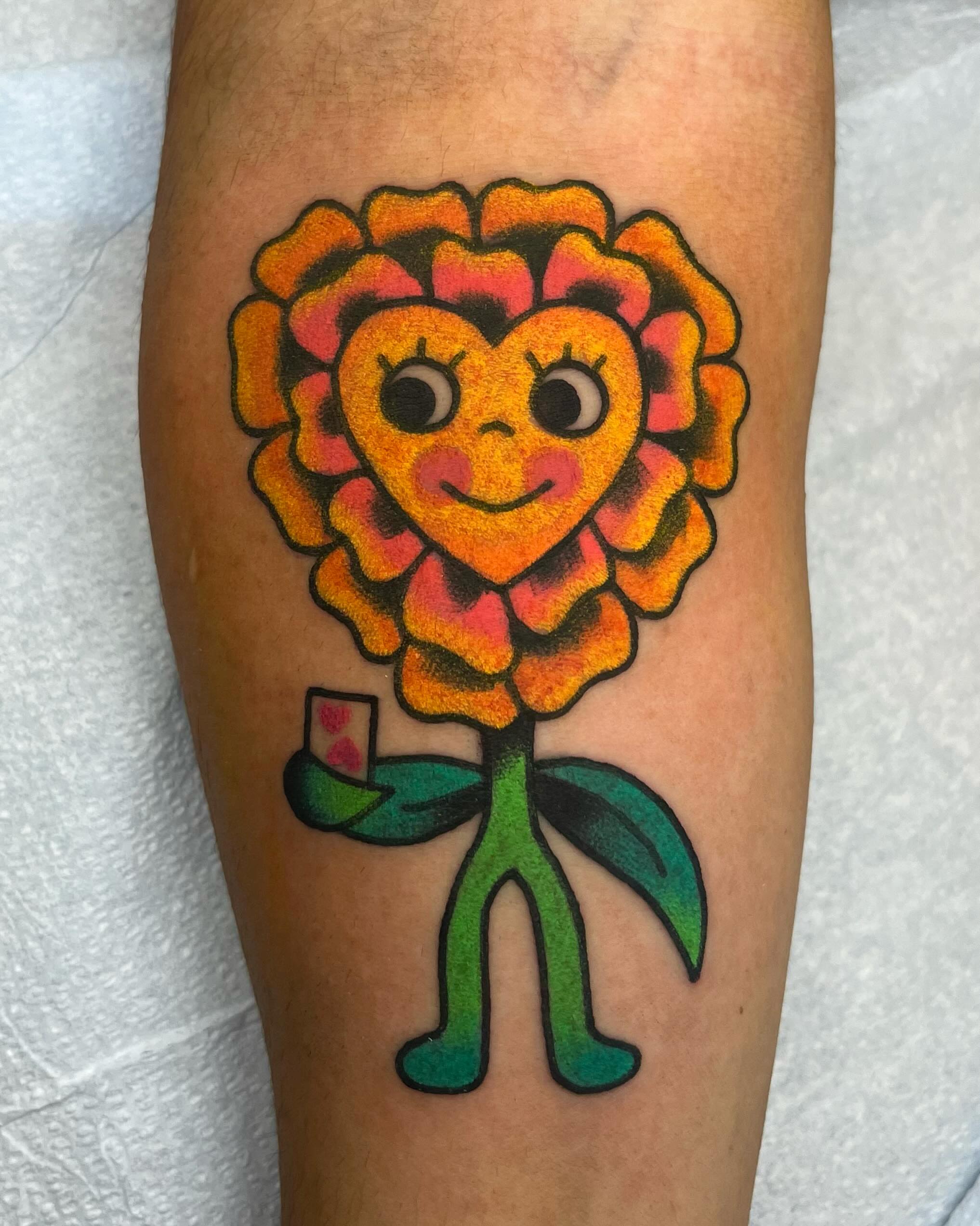 Flower with face new school tattoo on the forearm by Em Adkins