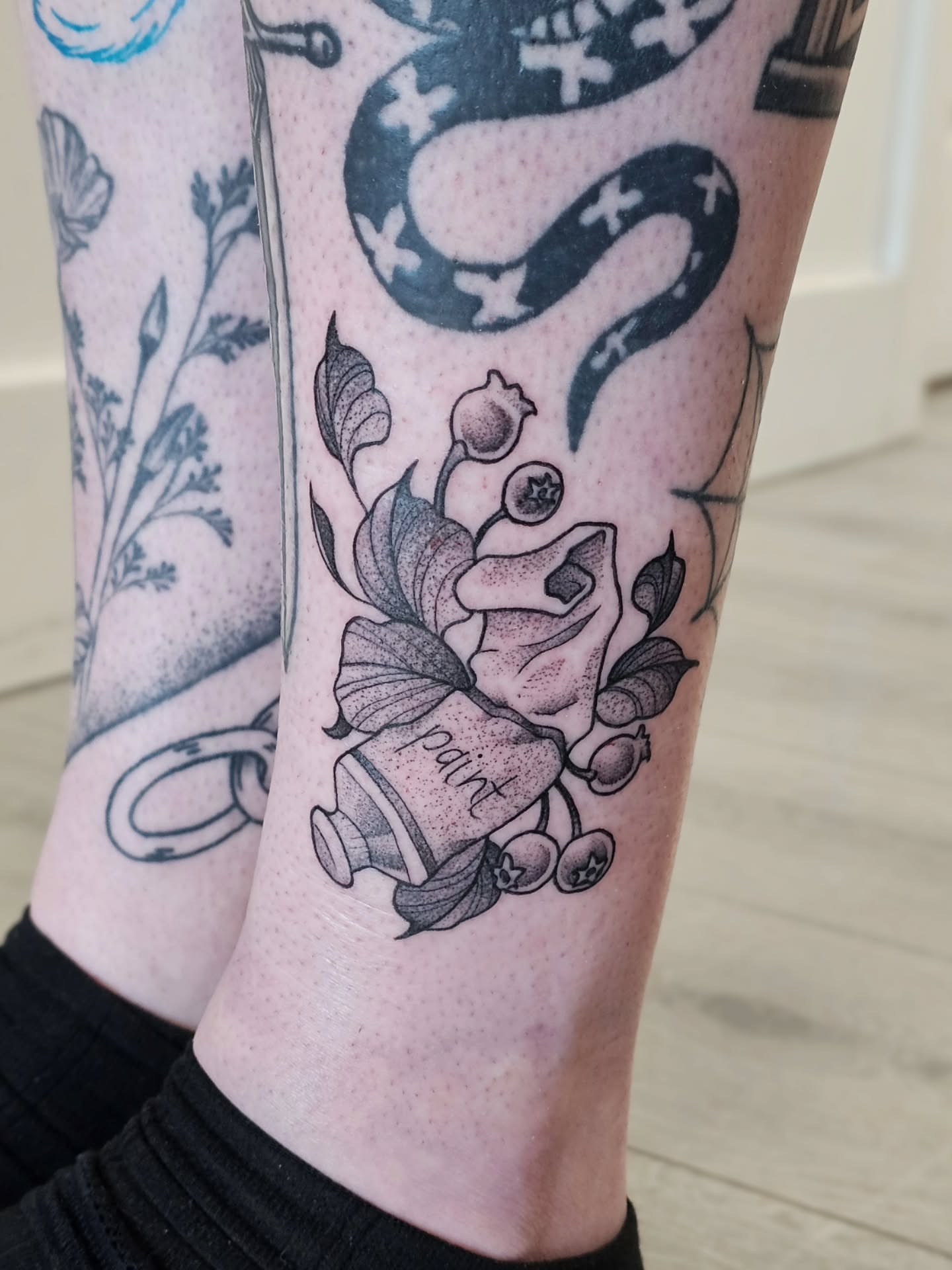 Paint can and floral arrangement American traditional tattoo on the calf by Kylie Lund