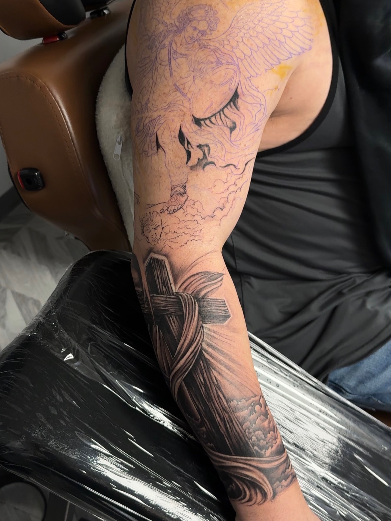Angel with cross realism tattoo on the forearm by Sebastian
